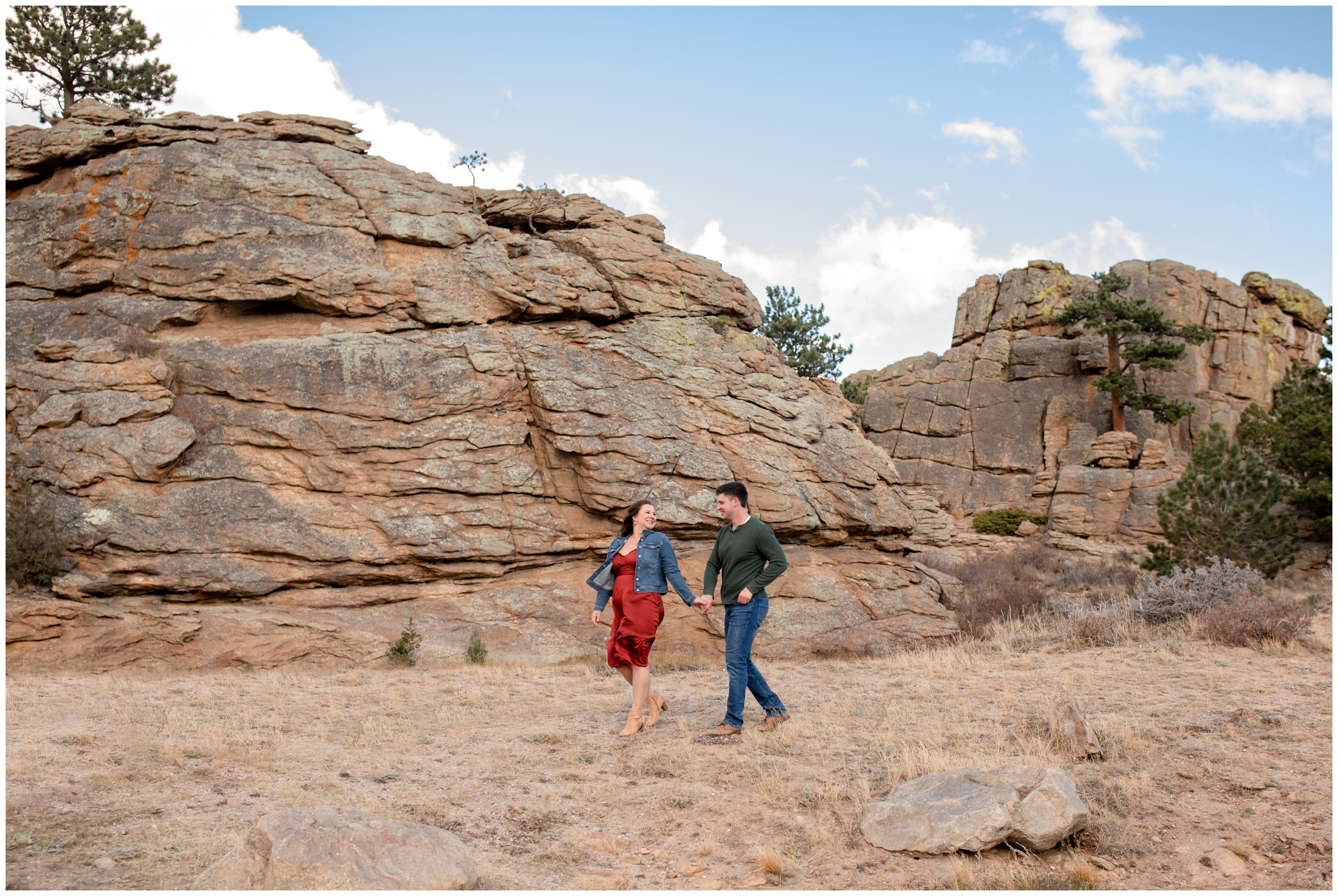 couple walking with rock formations in the background during Estes Park Colorado fall engagement session 