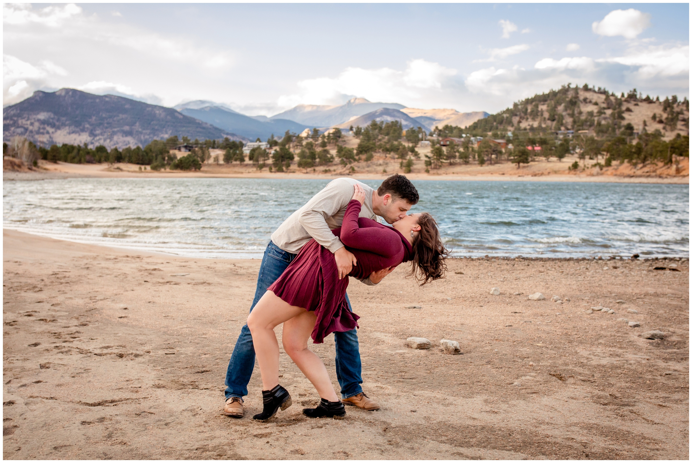 guy dipping his fiancé in front of Marys Lake during Estes Park Colorado engagement portraits 