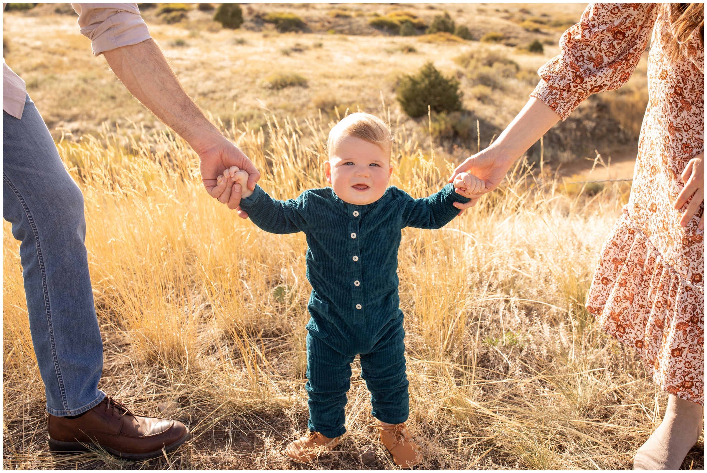 little boy holding parents hands during Mount Falcon family photos in Colorado 