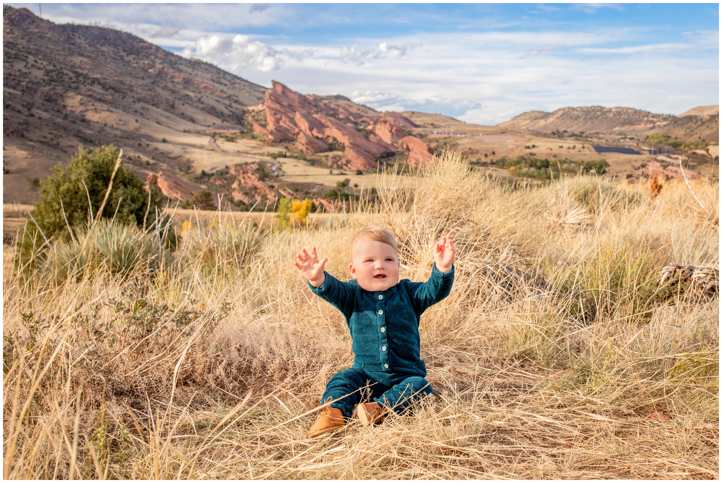 baby boy sitting in long grass during outdoor family photography session in Morrison Colorado 