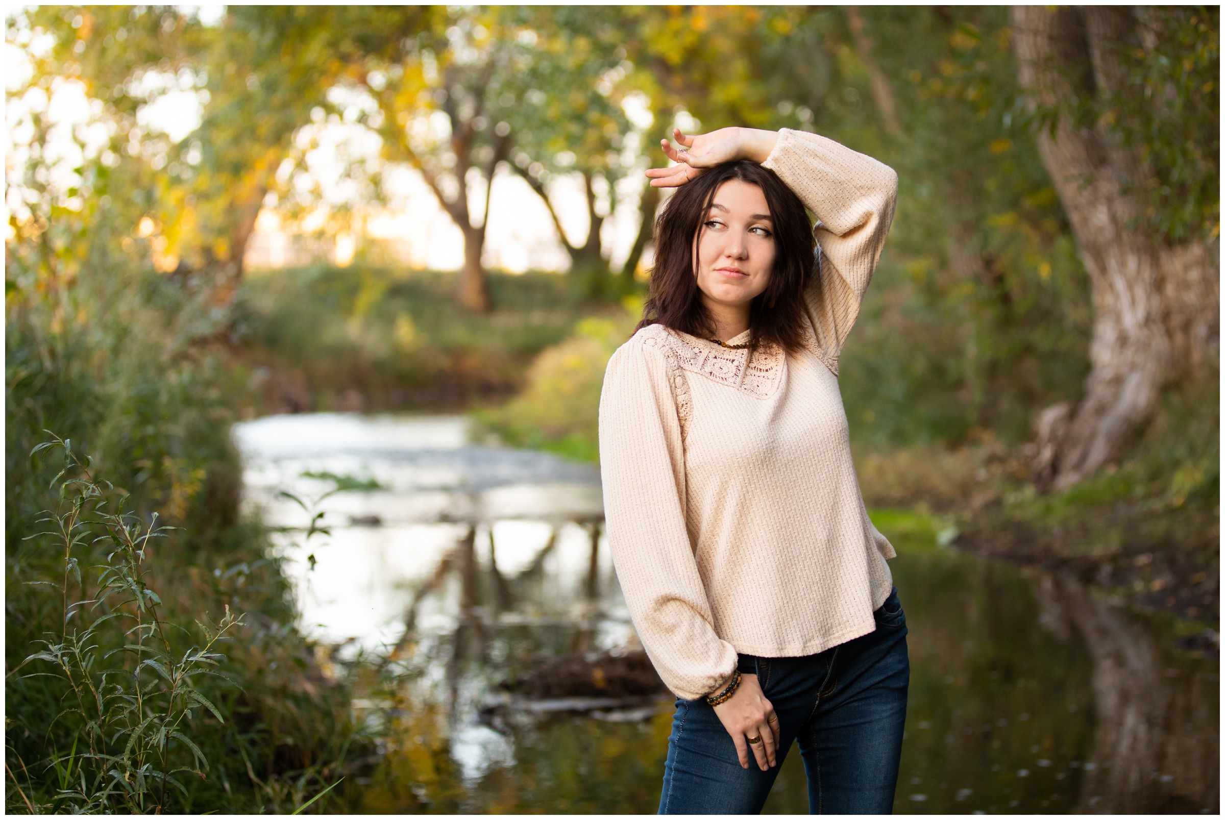 teen posing along river during Longmont Colorado senior pictures