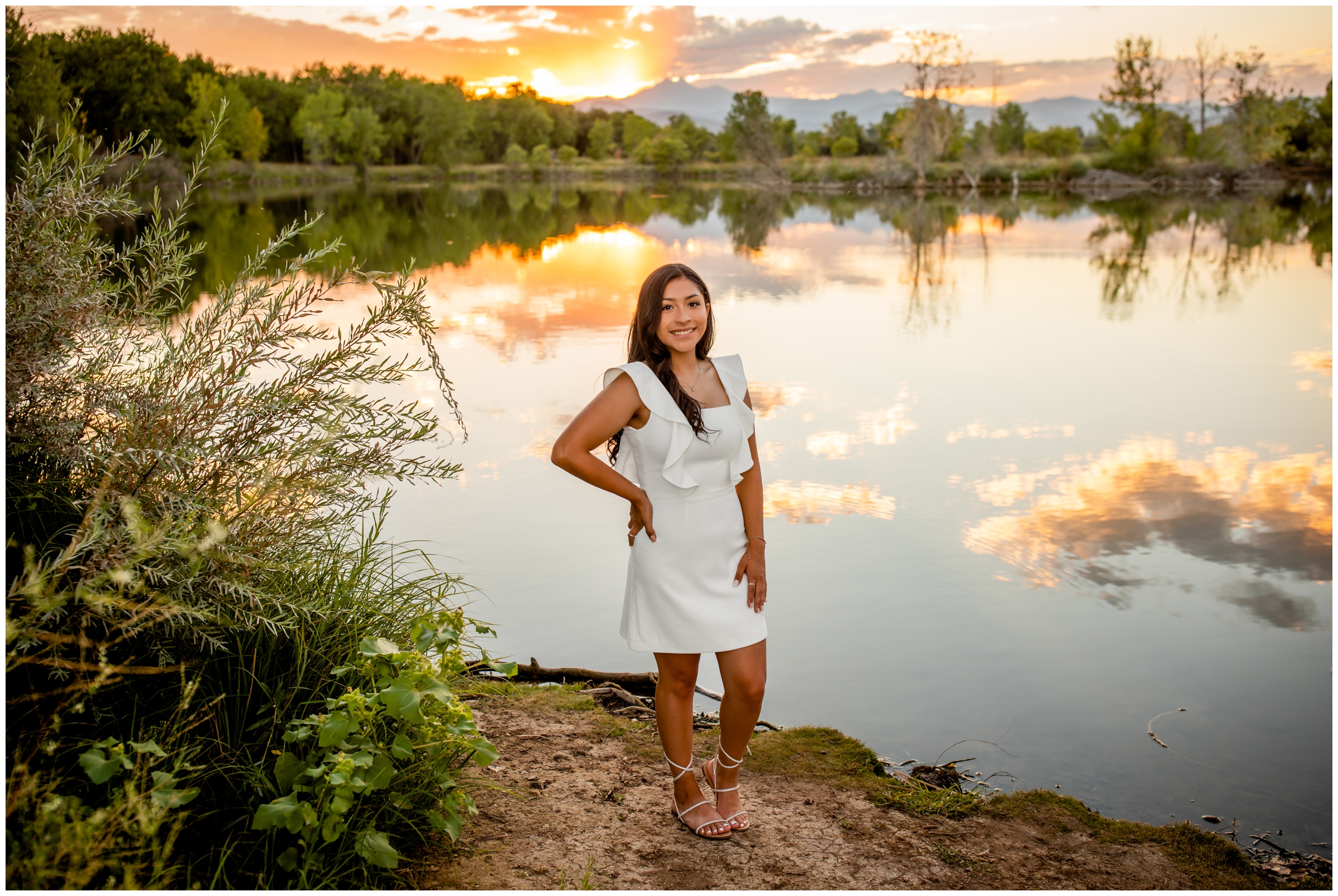 teen girl posing by a lake at sunset during Longmont Colorado senior photography session 