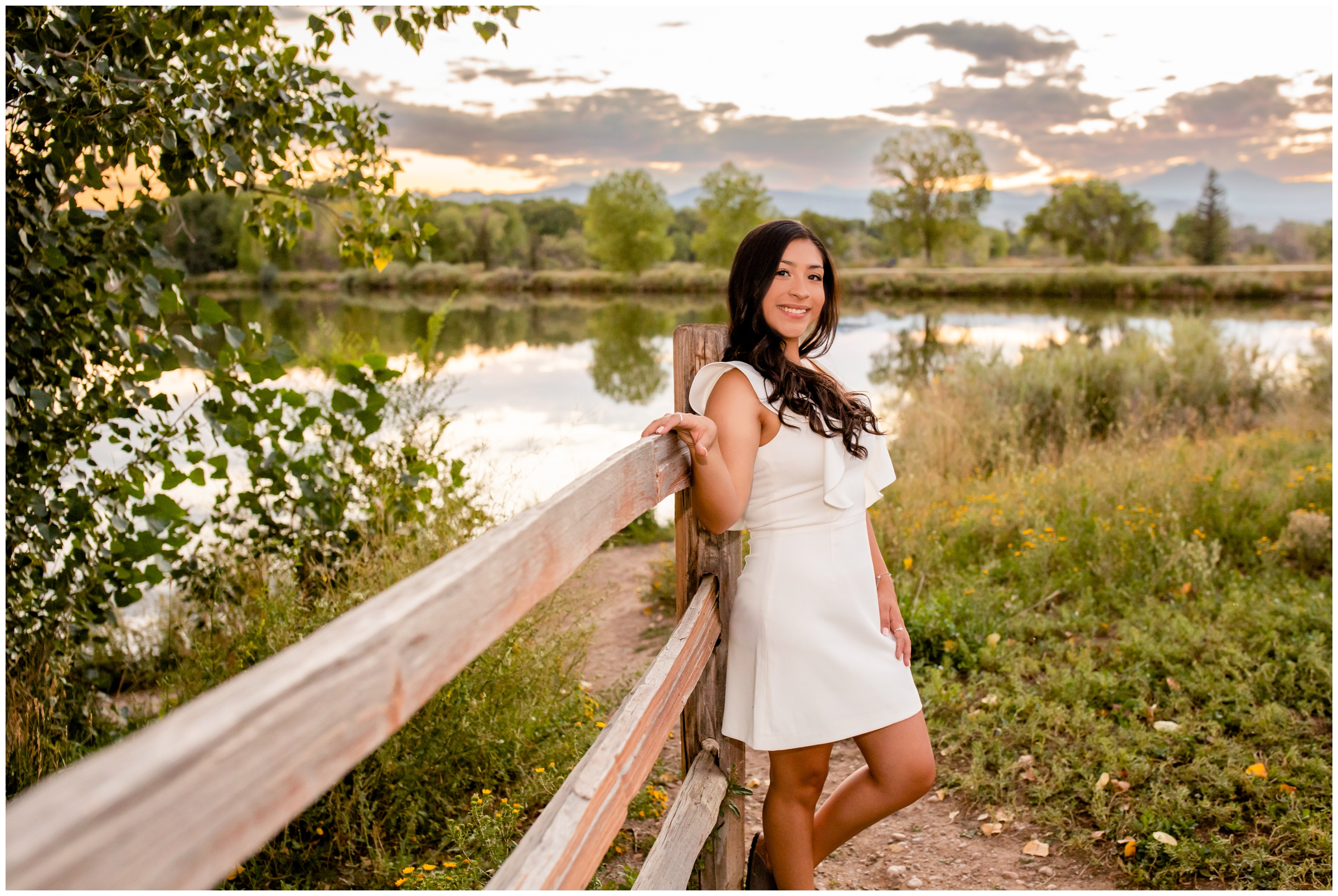 teen girl leaning against a wooden fence at sunset during Colorado senior pictures by Plum Pretty Photo