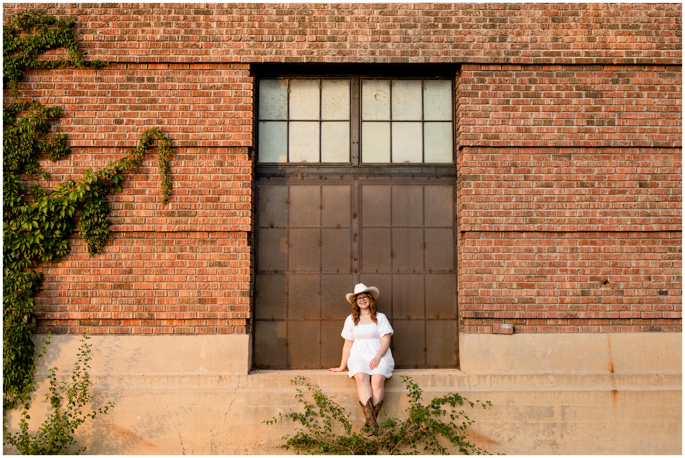 teen sitting on brick wall during urban senior photos in Boulder Colorado