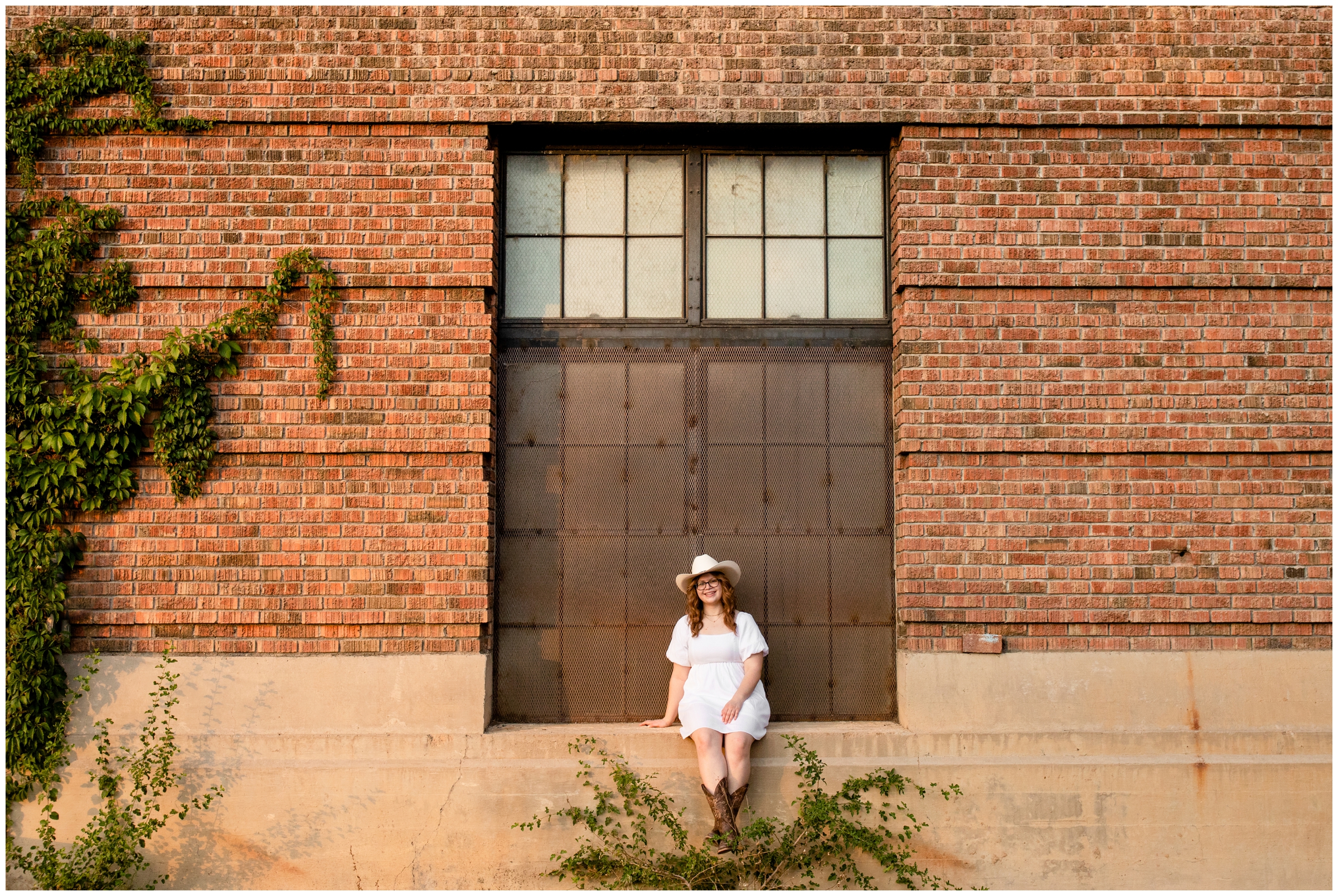 teen sitting on brick wall during urban senior photos in Boulder Colorado 