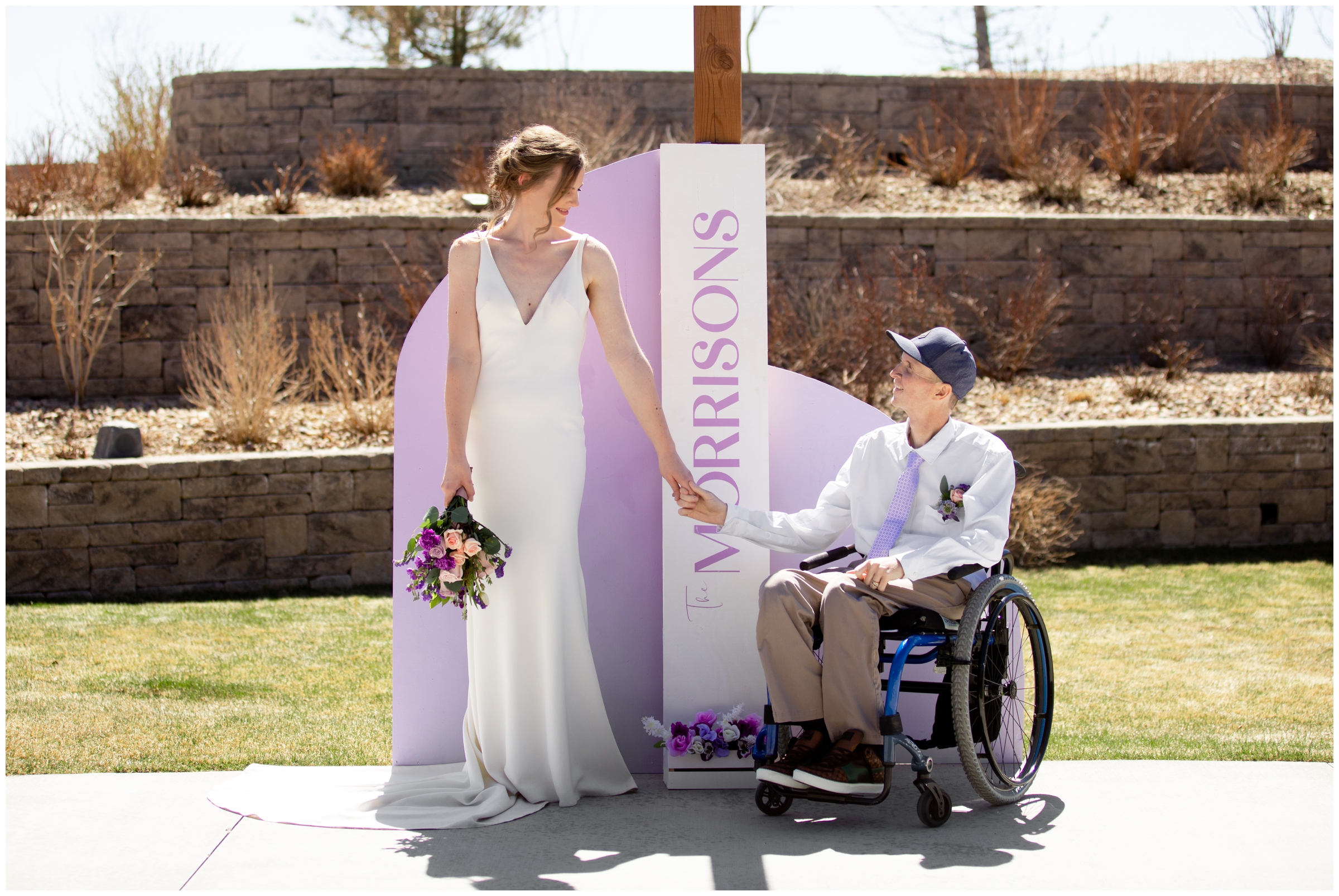 couple posing in front of custom sign with new last name at spring wedding in Elizabeth Colorado 