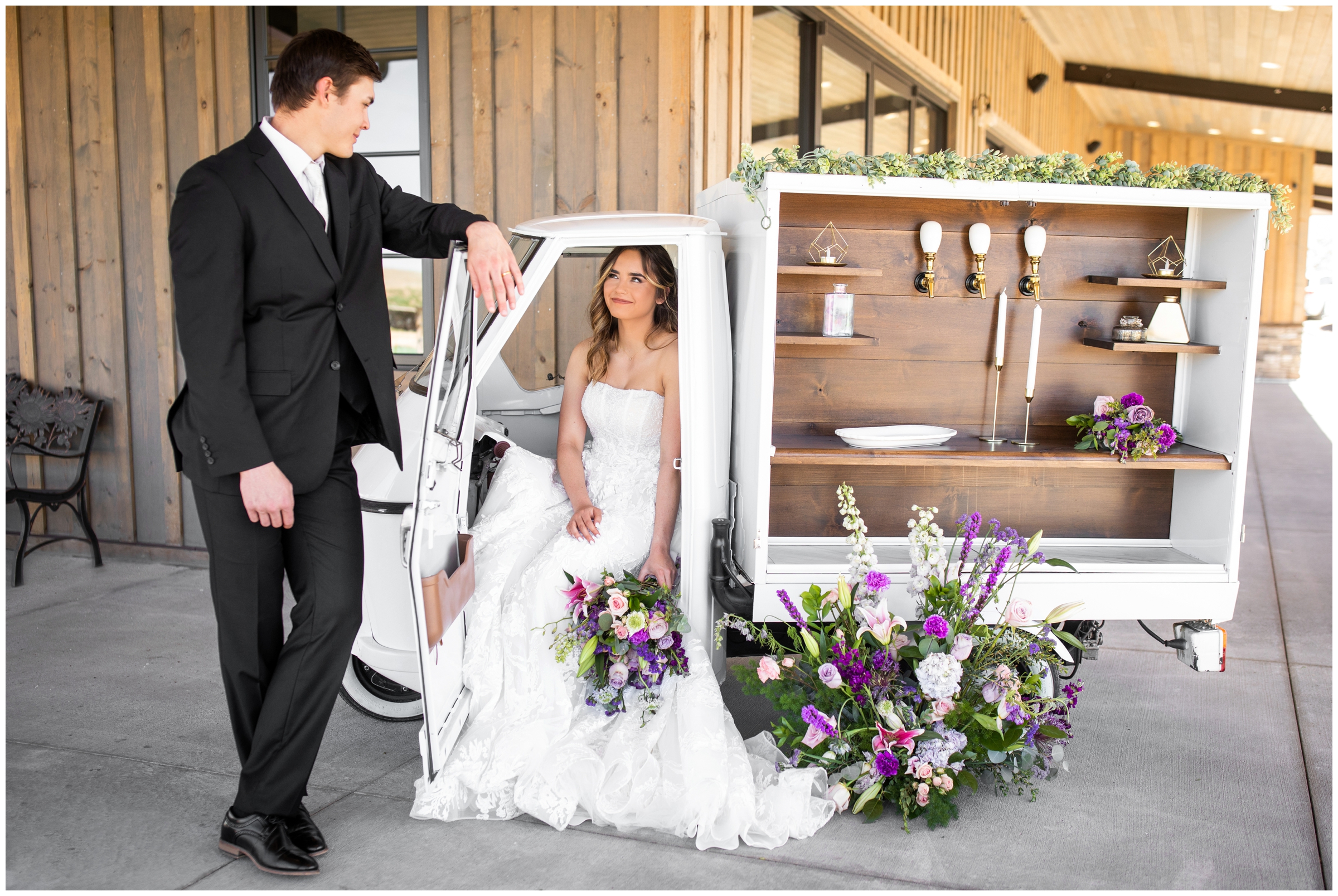 couple posing in La Piccolina mobile bar cart during Bonnie Blues Colorado wedding photos by Plum Pretty Photography