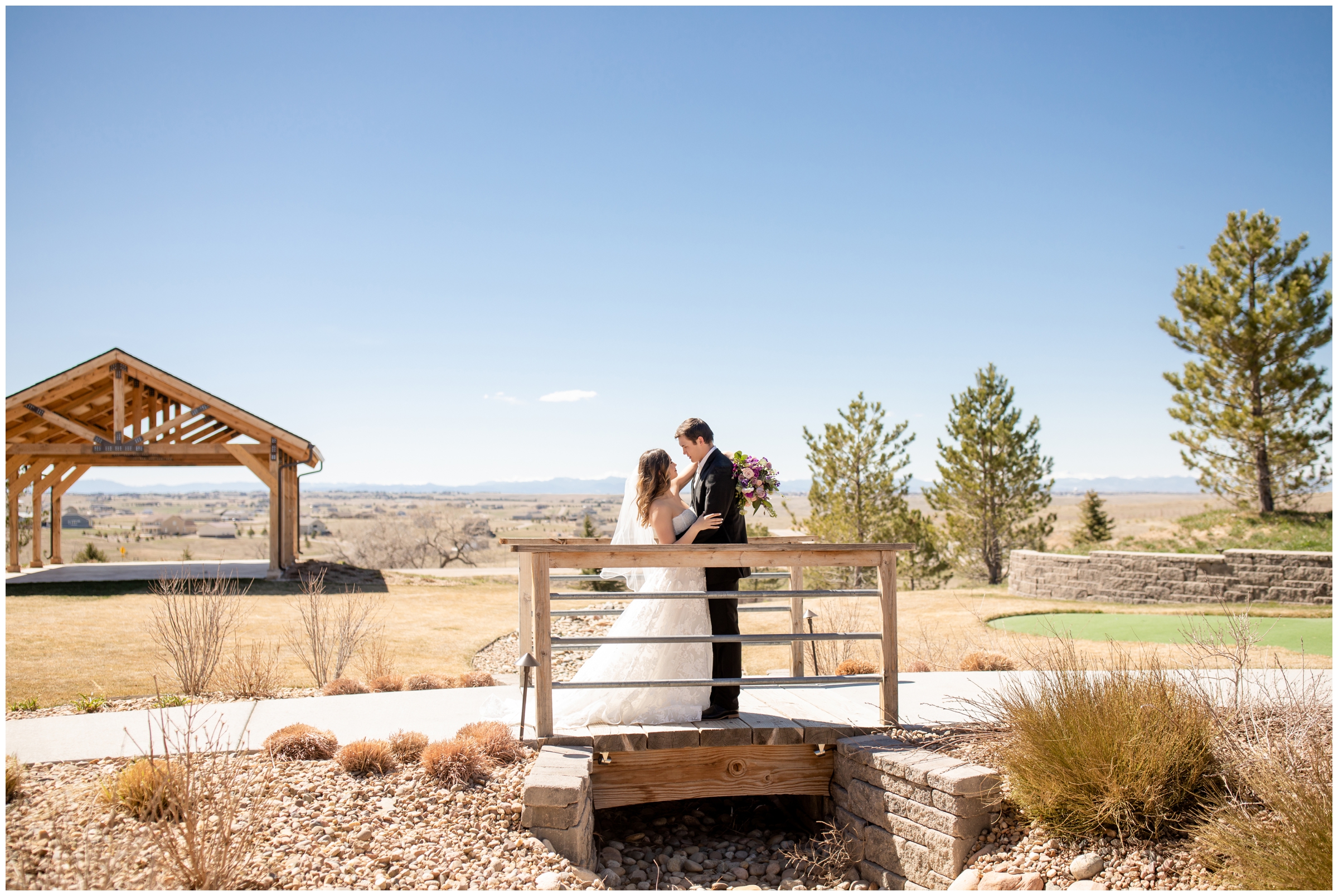 couple posing on wooden bridge at Bonnie Blues Event Venue during spring wedding portraits in Colorado 