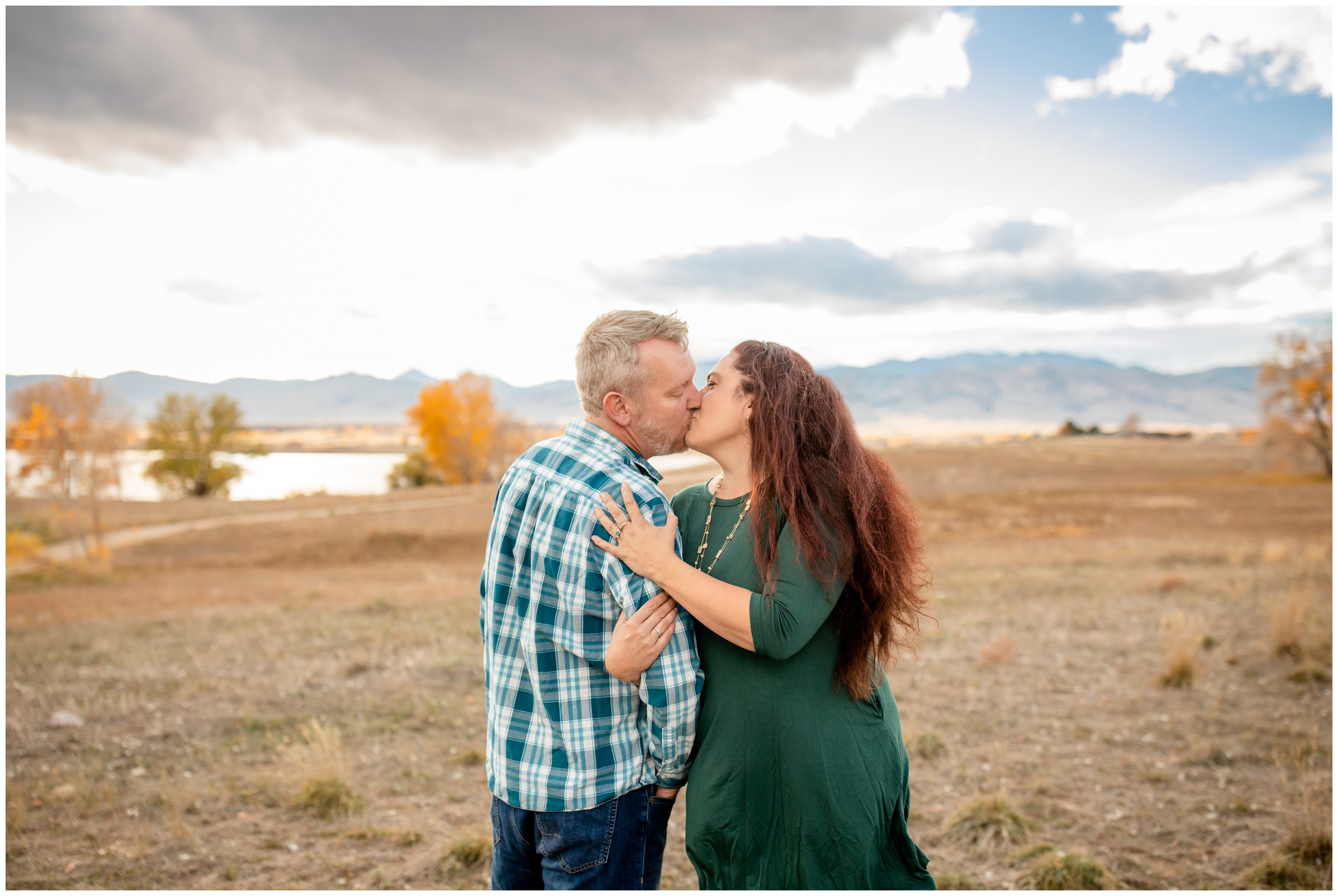 couple kissing in a field during engagement portraits at Boulder Reservoir in Colorado