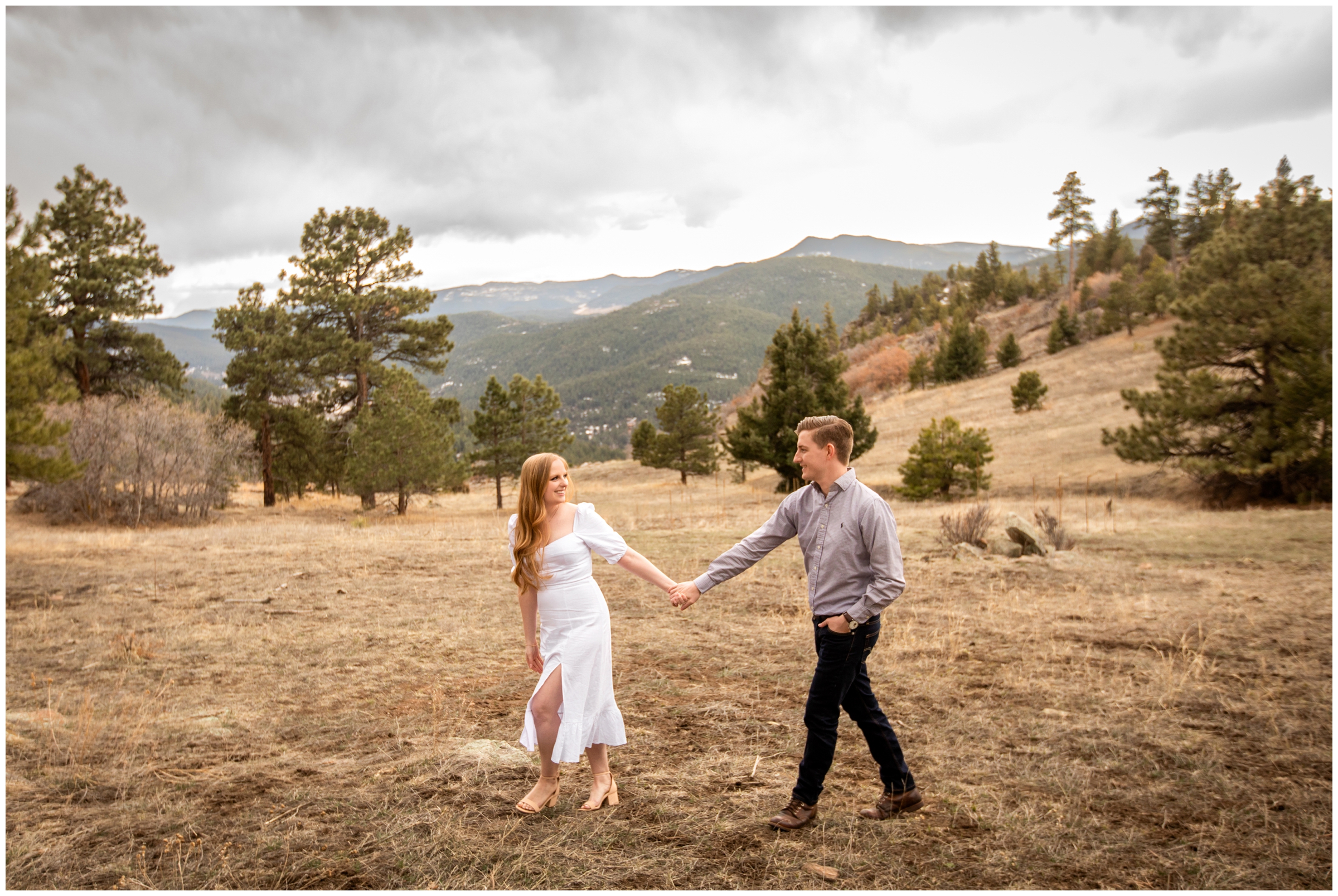 couple walking in mountain field during spring anniversary photos in Morrison Colorado 