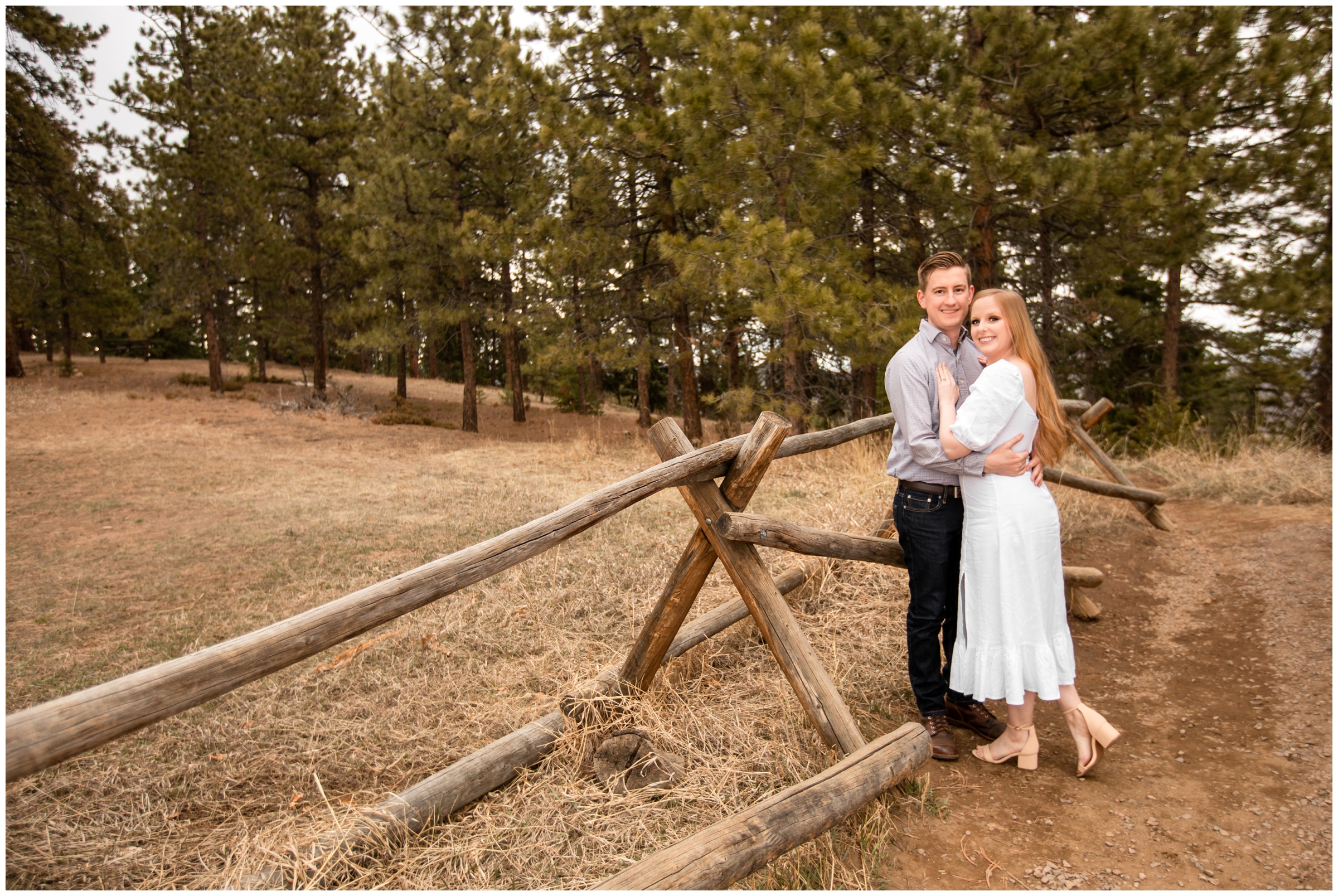 couple leaning on wooden fence in the CO mountains 
