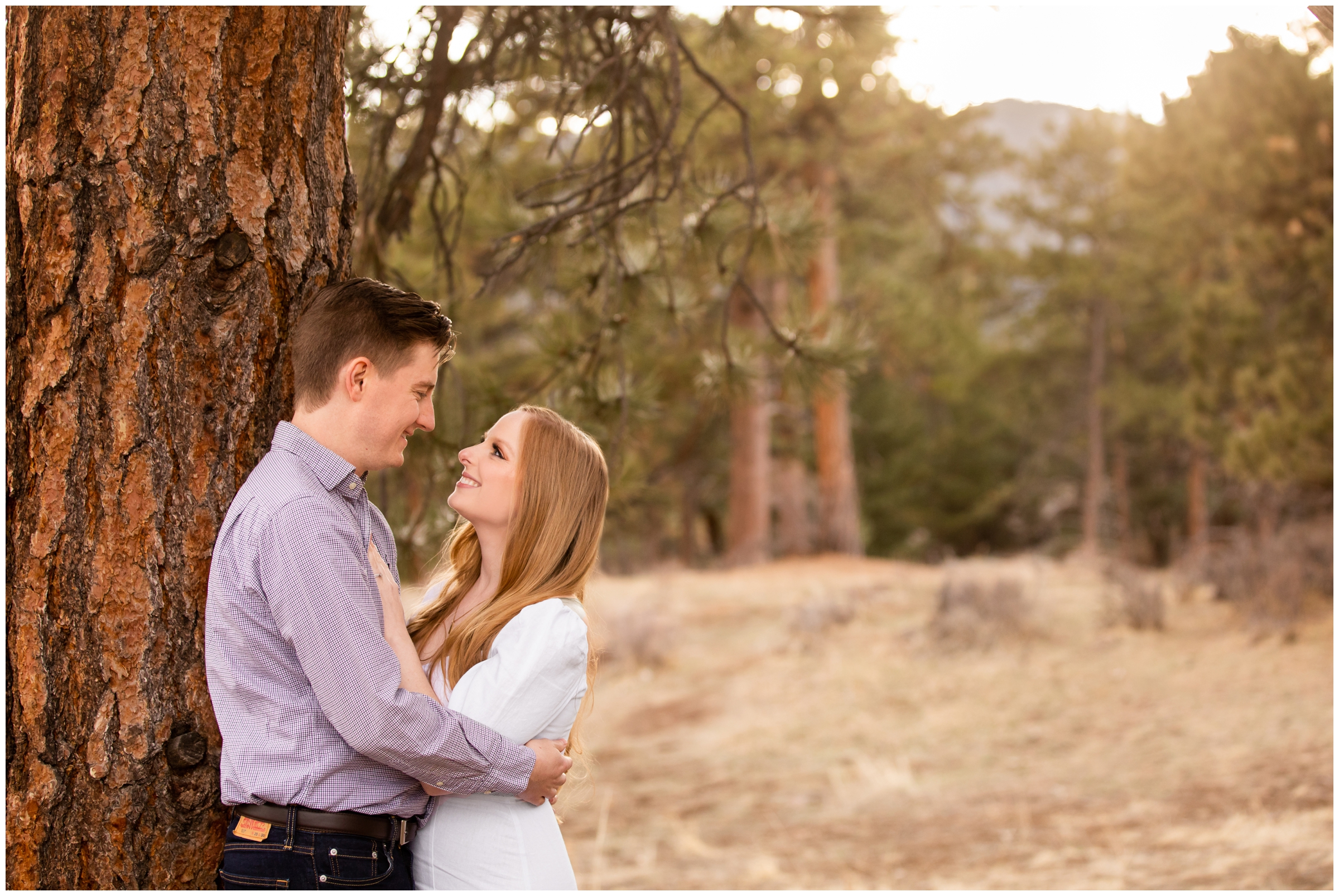 couple leaning against a tree during golden hour at Colorado anniversary photo session at Mount Falcon Park 