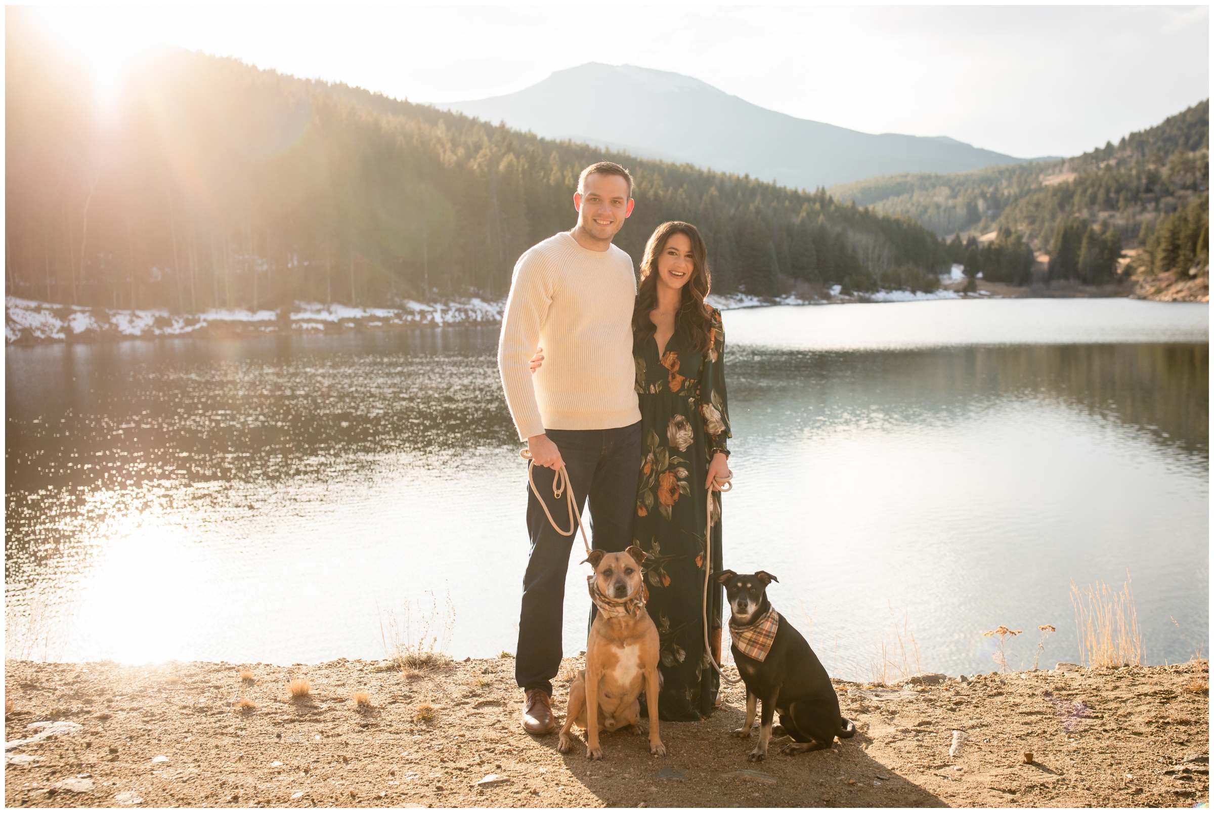 couple posing with their dogs at a reservoir in the Evergreen Colorado mountains