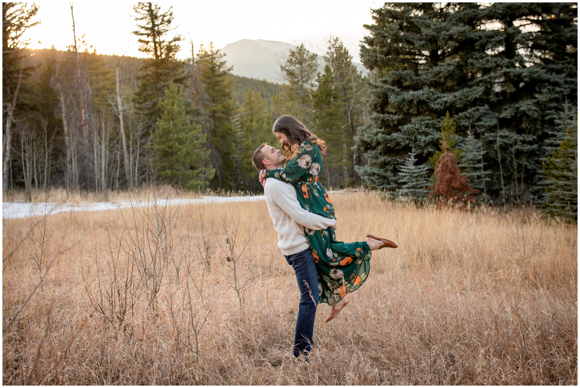 man lifting his wife in a mountain field during Evergreen Colorado anniversary couples portraits 