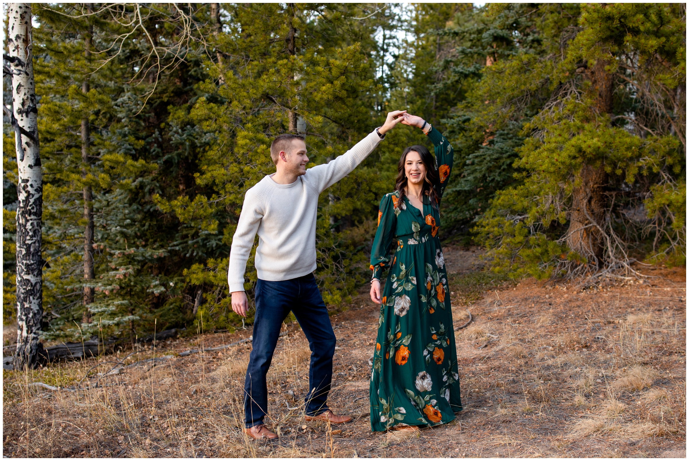 couple twirling in a Evergreen CO forest during anniversary photo session 