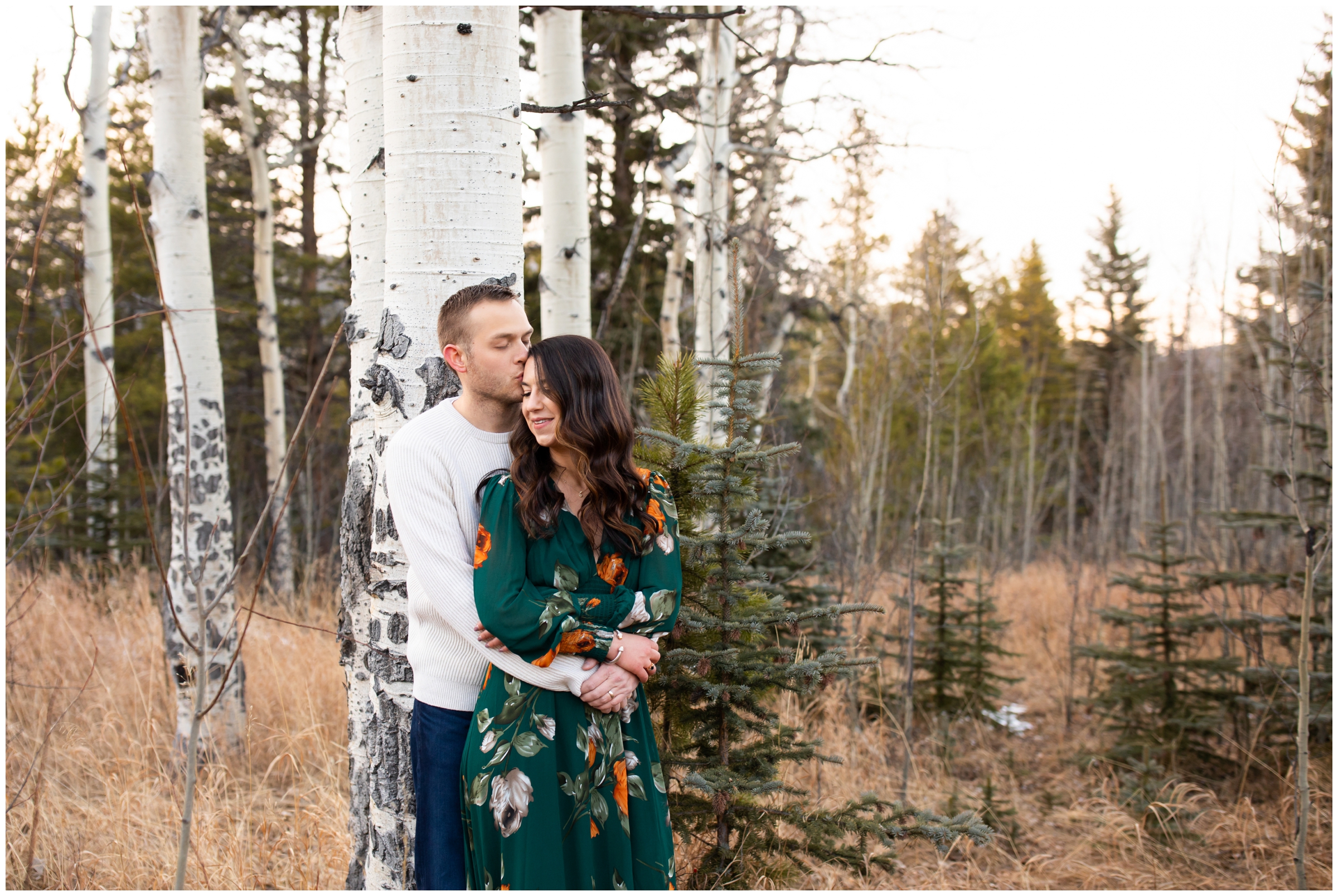 couple cuddling in aspen grove during Evergreen Colorado fall engagement pictures 