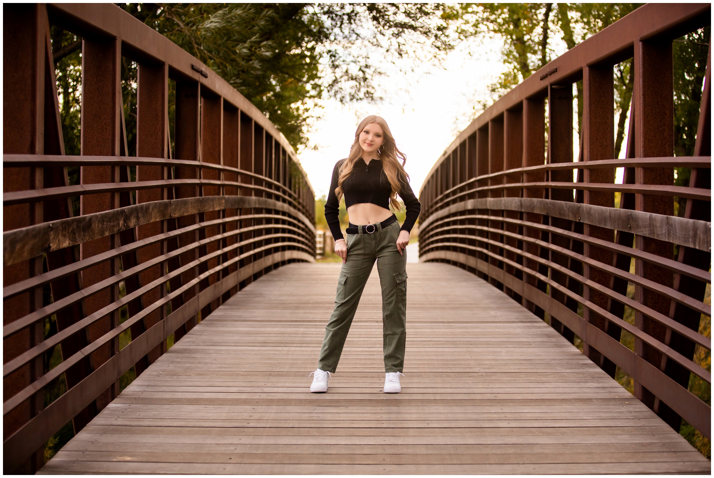 teen posing on bridge at Sandstone Ranch during fall senior pictures in Longmont Colorado 