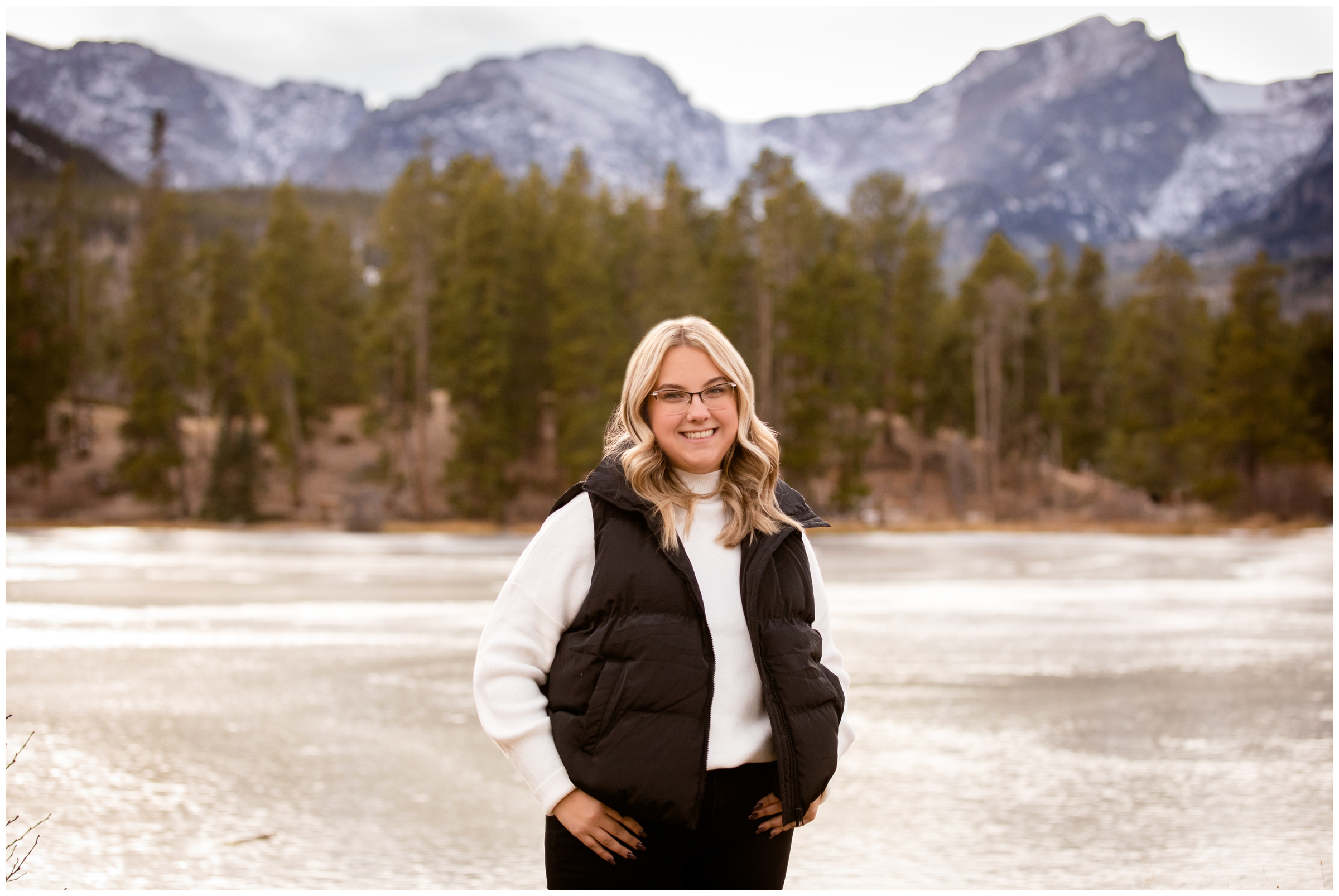 teen posing in front of mountain lake during senior photos in Estes Park Colorado 