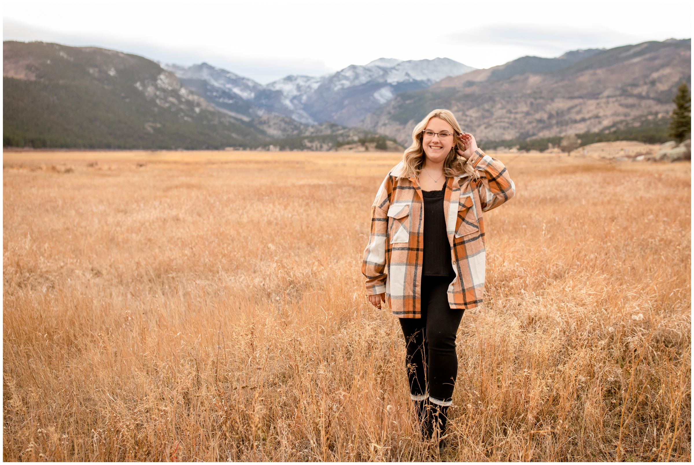 teen walking through field at Moraine Park during mountain senior photo session in Estes Park Colorado