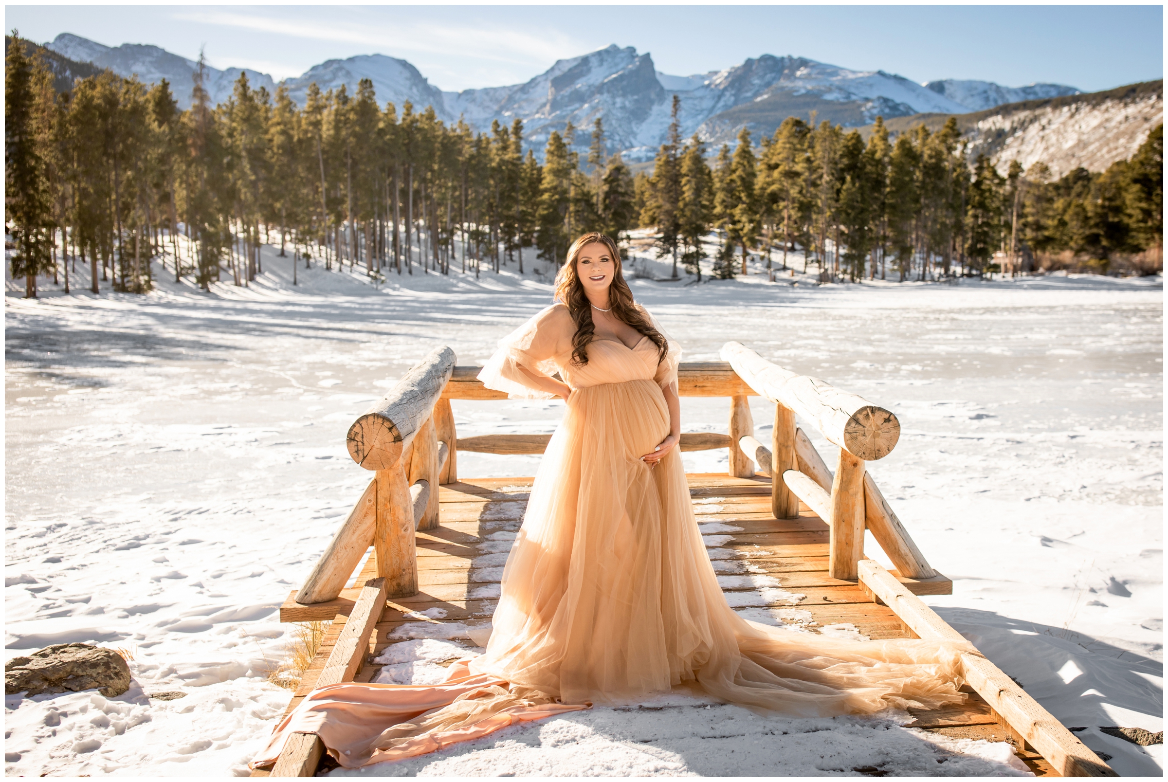 pregnant woman posing on dock at Sprague Lake during Colorado winter maternity photography by Plum Pretty Photos