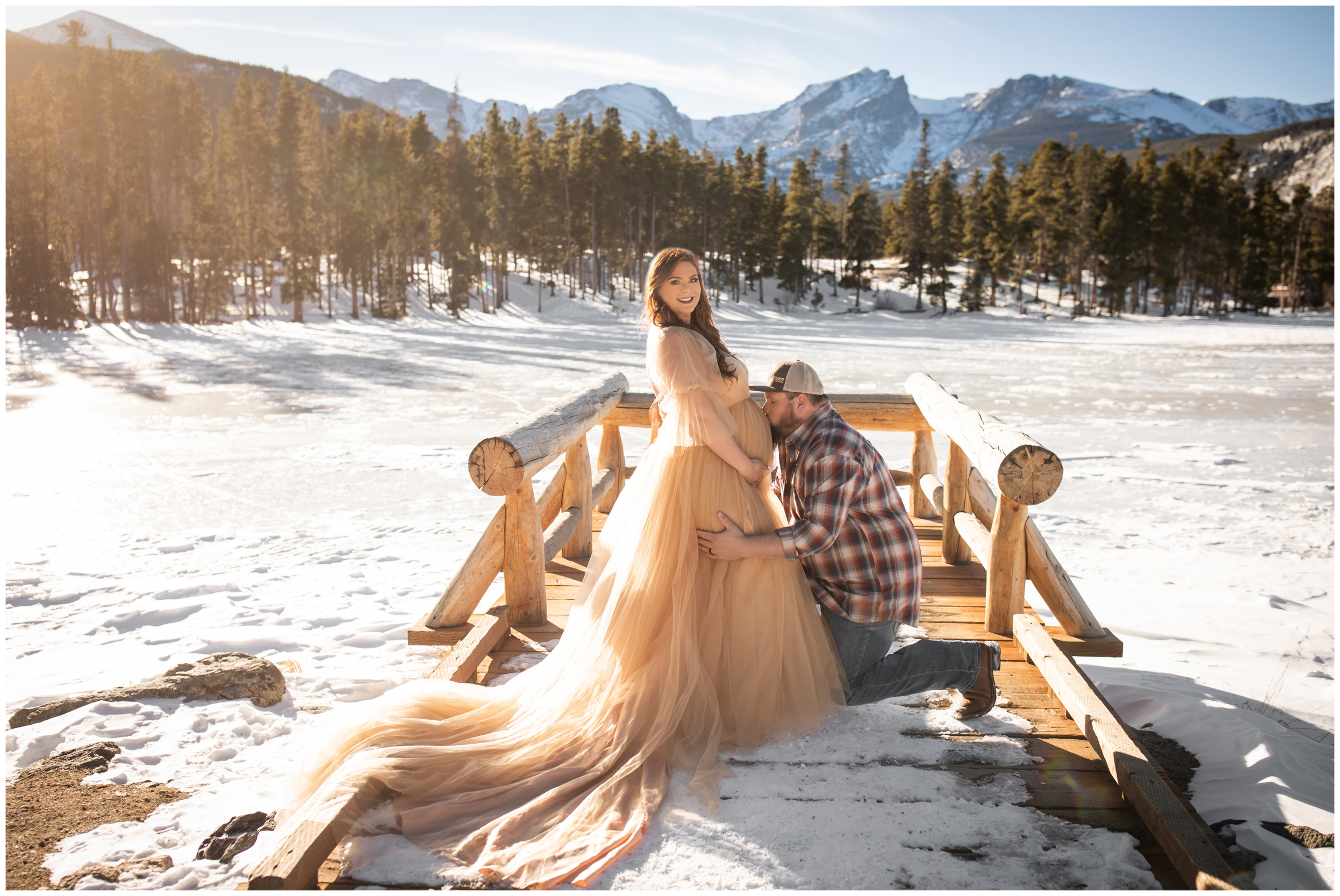 husband kissing wife's belly during Colorado winter maternity portraits in Rocky Mountain National Park