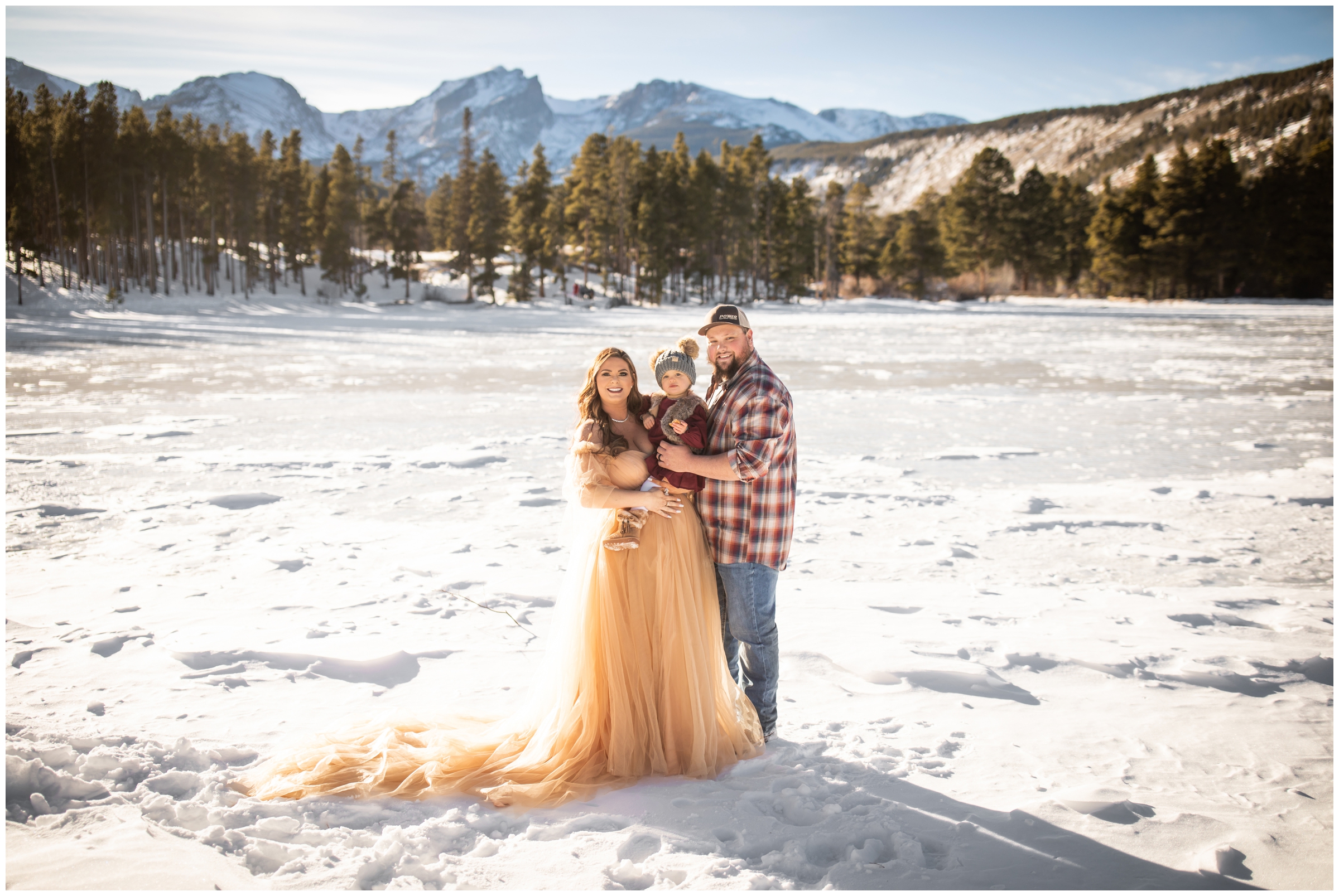 family posing on a frozen lake in Estes Park during snowy family photo shoot in RMNP