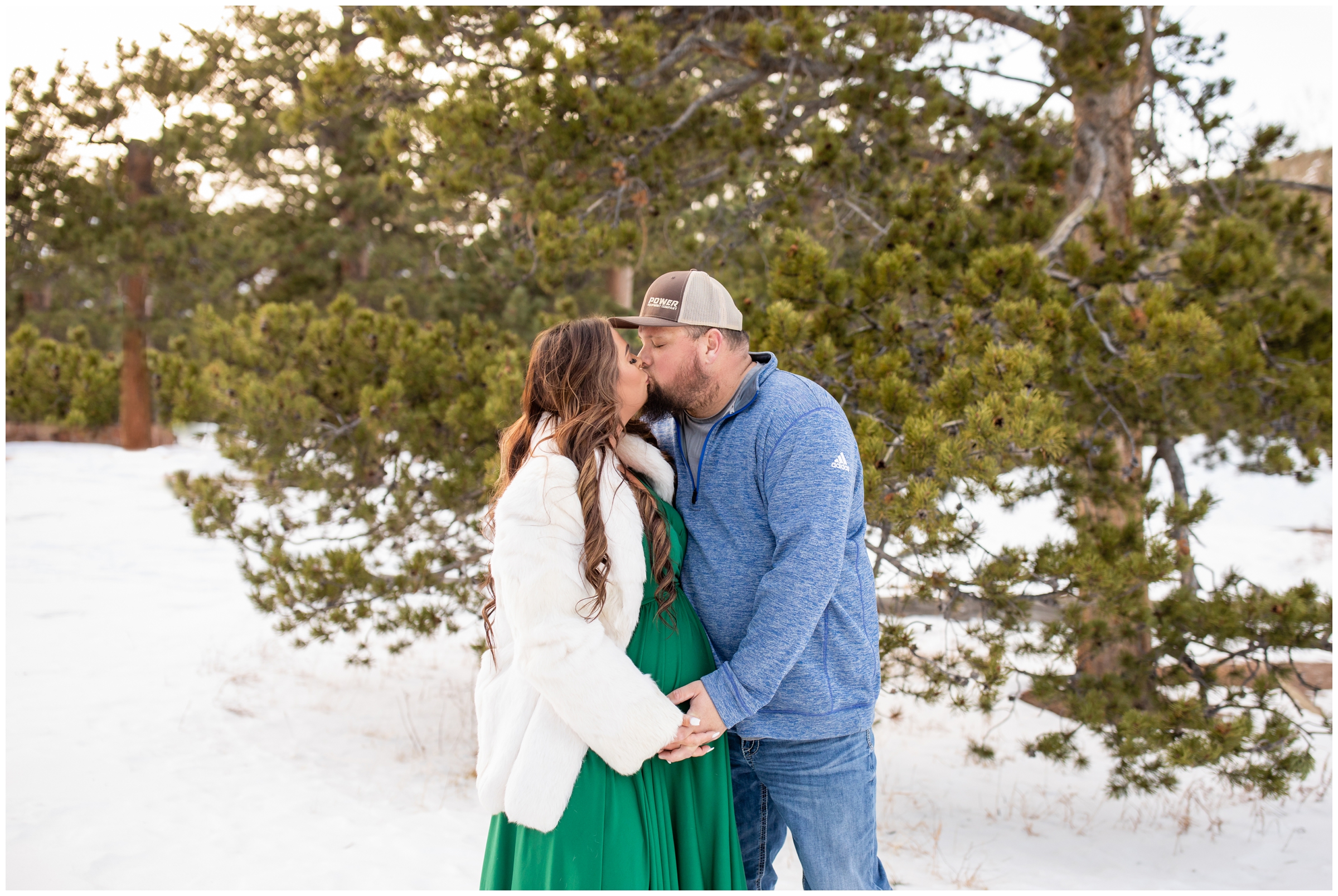 couple kissing in the snow during Estes Park maternity photography session 