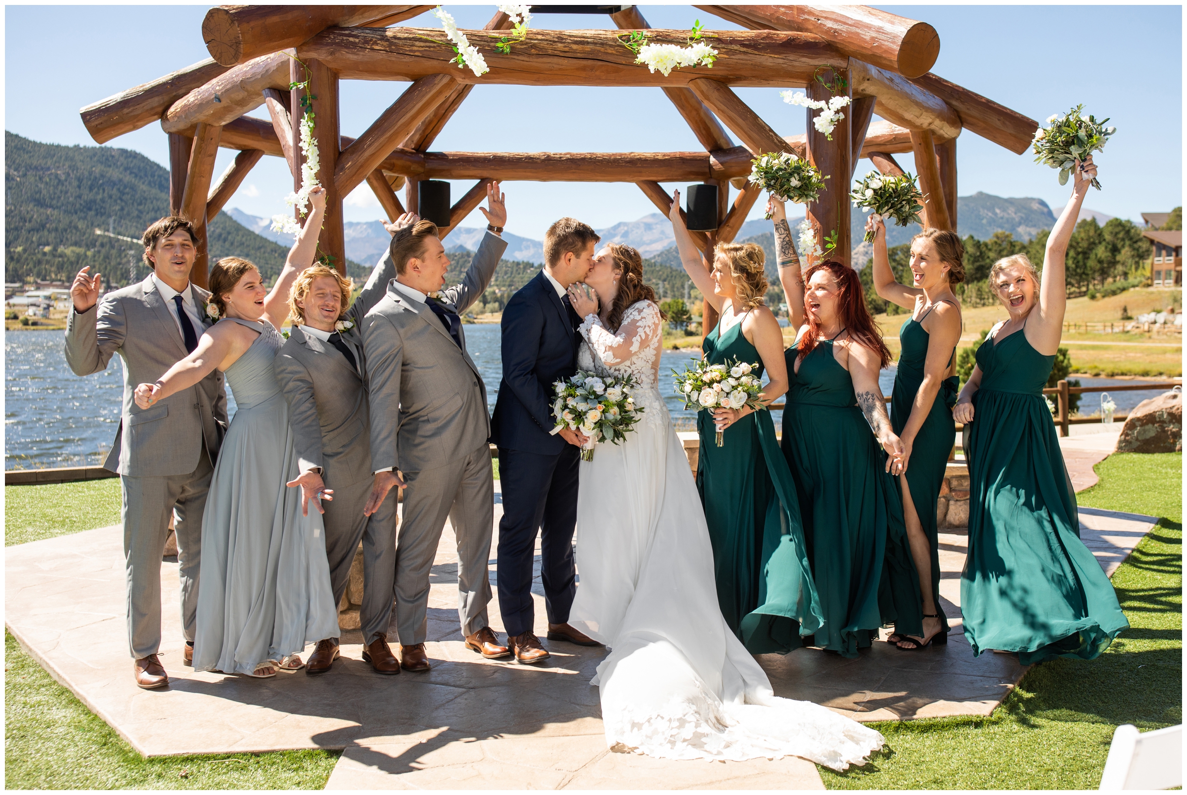 wedding party in gray and green cheering under arbor at Estes Park Resort