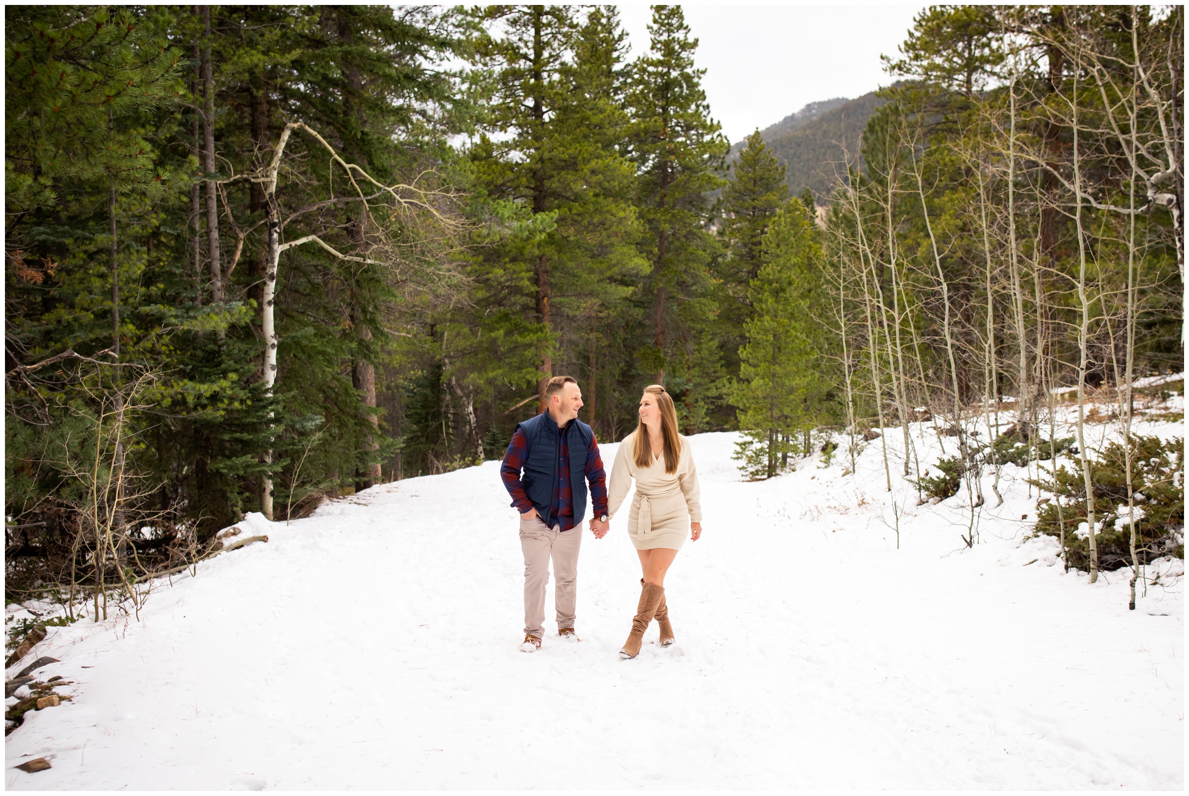 couple walking in the snow during candid winter engagement photo shoot in the Colorado mountains
