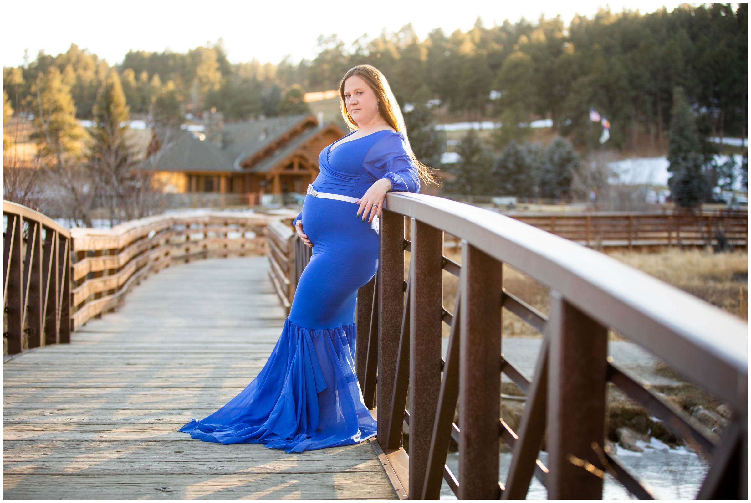 pregnant woman leaning against bridge during winter maternity portraits at Evergreen Lake in the Colorado mountains 