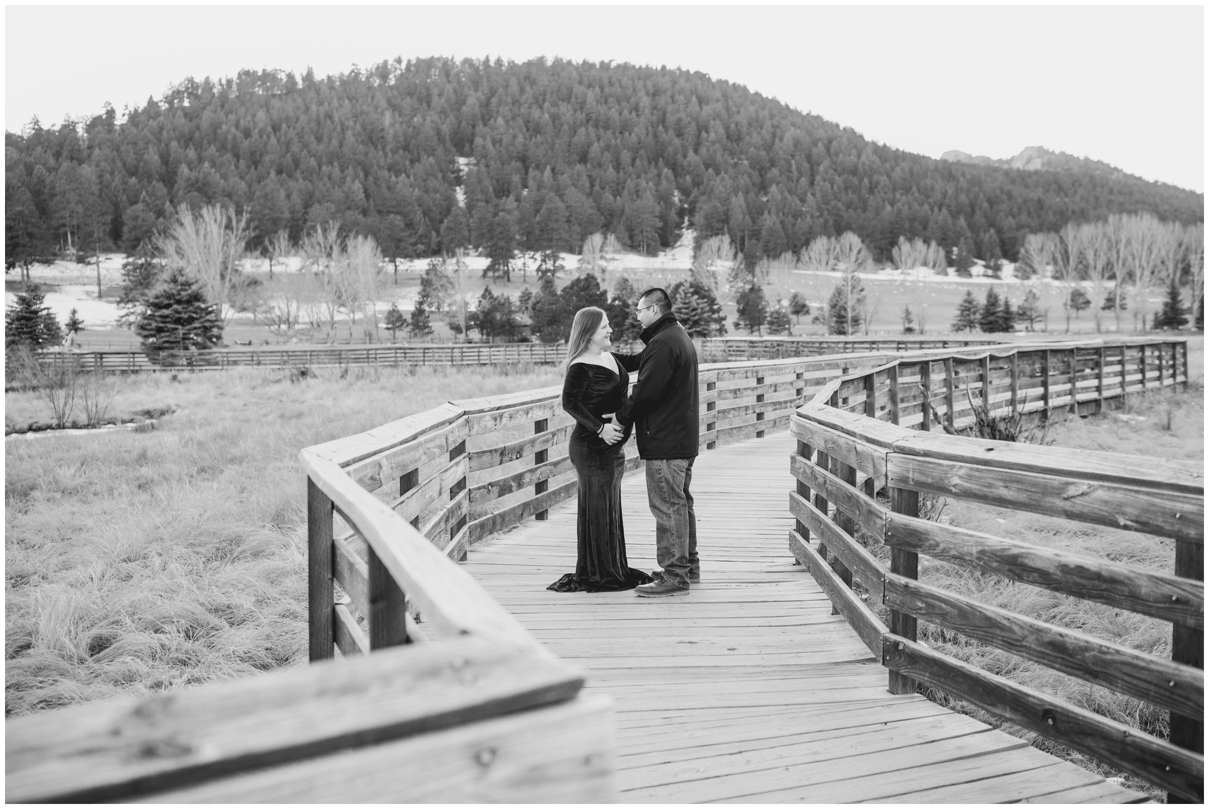 couple posing on wooden bridge during Colorado mountain maternity session at Evergreen Lake House