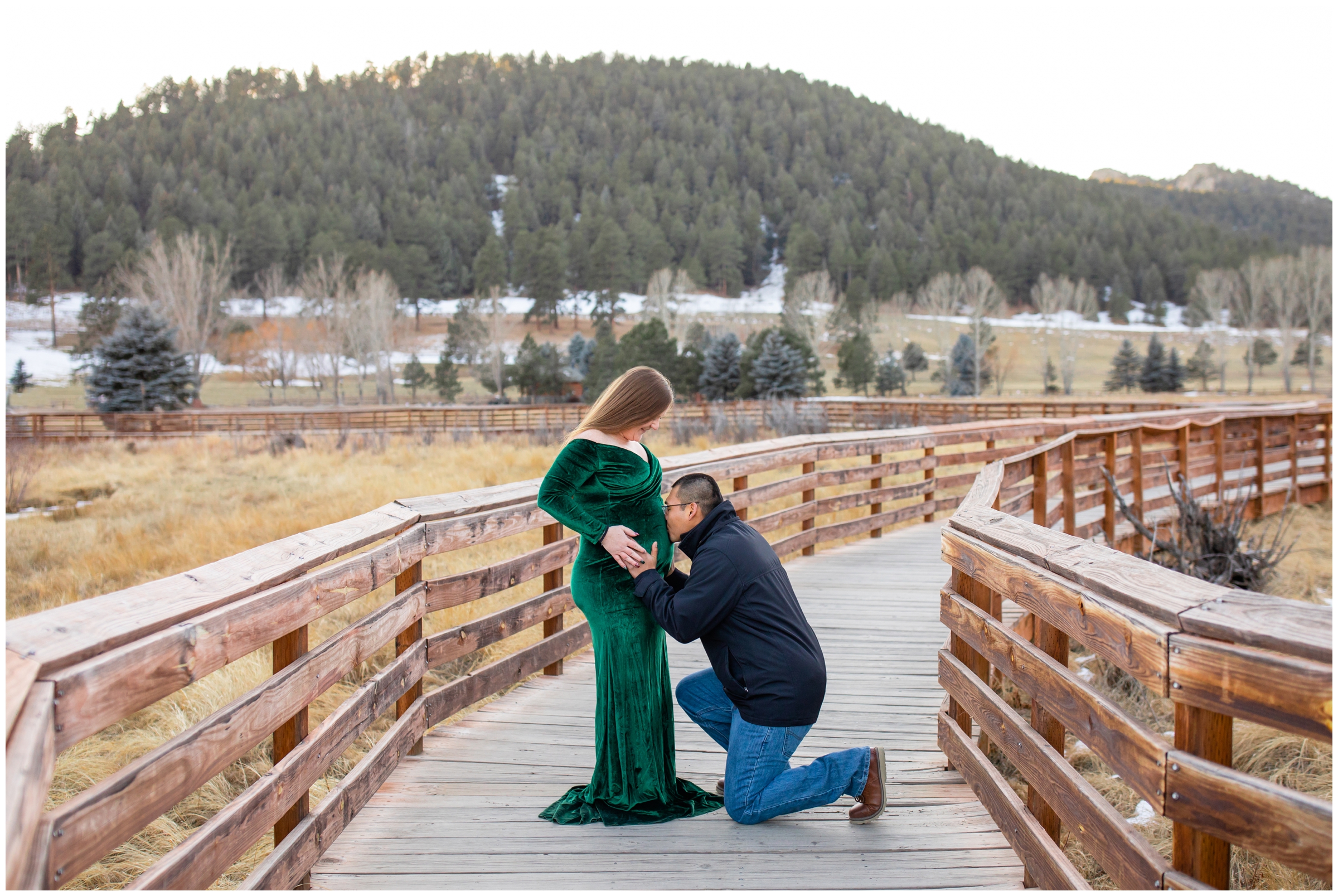 man kissing wife's belly during winter maternity pictures at Evergreen Lake