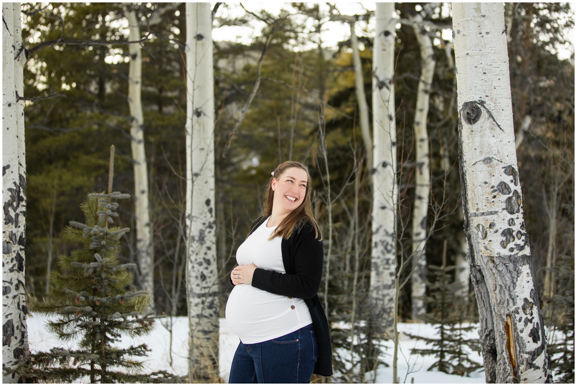 pregnant woman posing in aspen grove during snowy winter maternity photos in Evergreen Colorado 