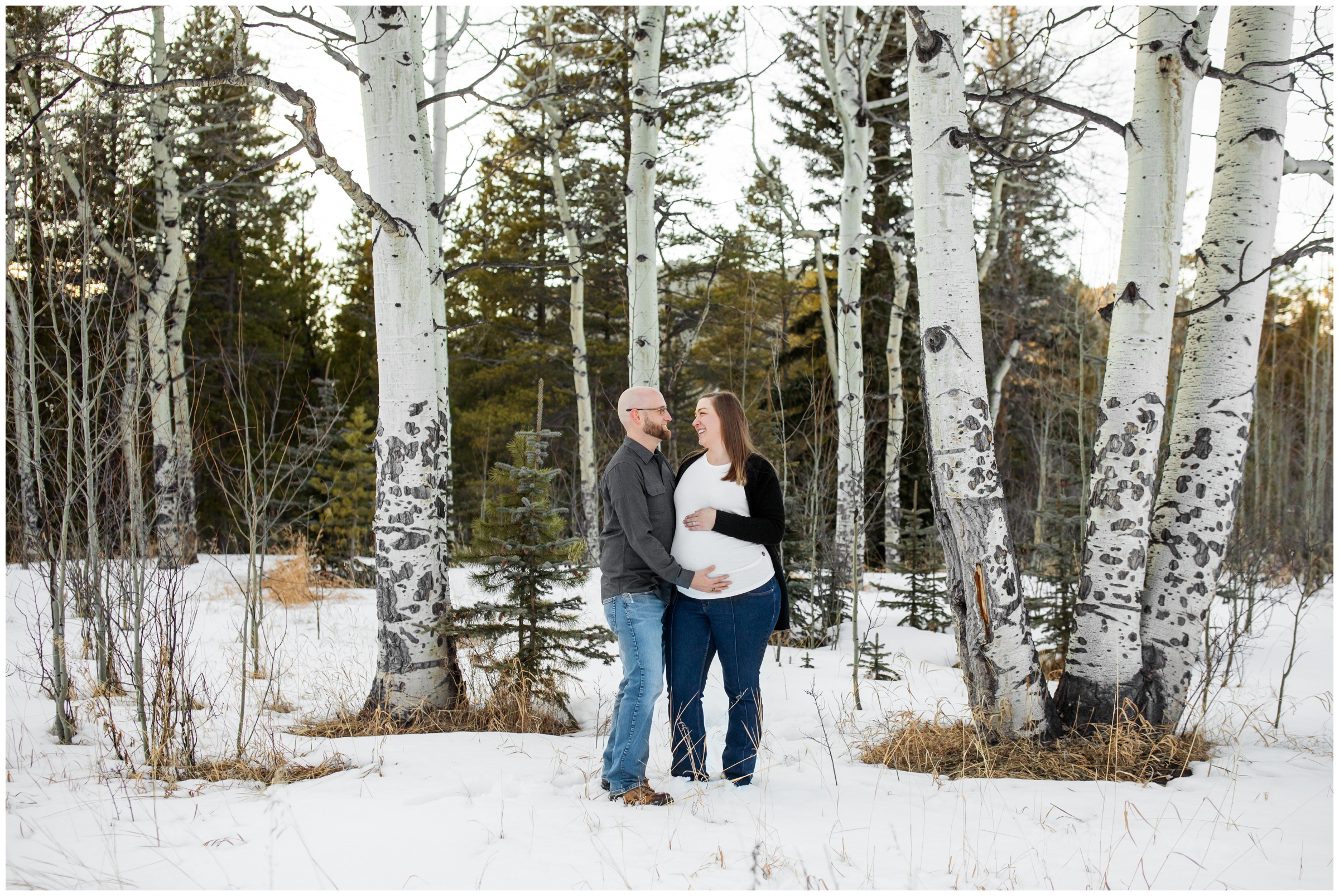 couple posing in aspen grove during winter maternity pictures at Frosberg Park in Evergreen Colorado 