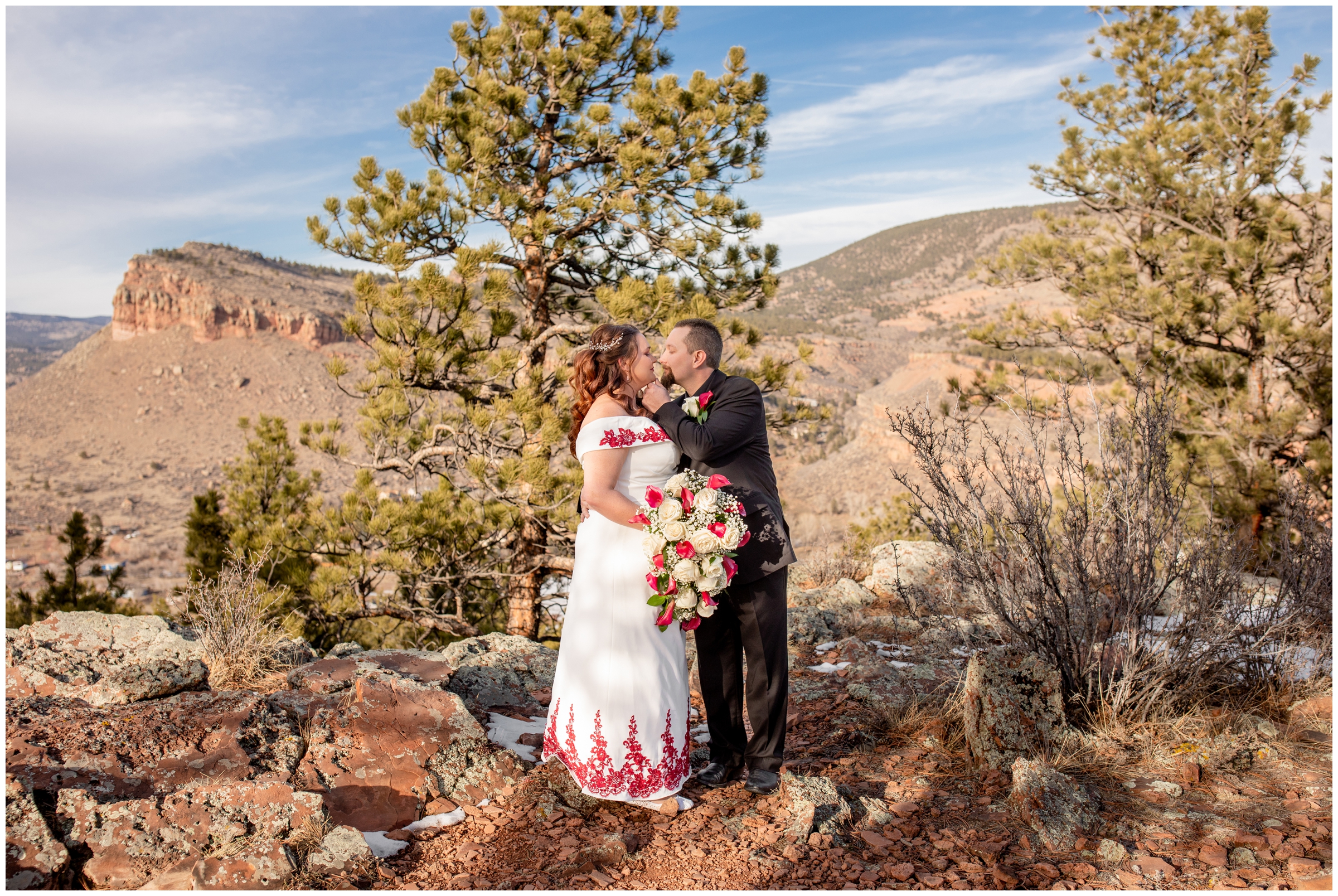 couple kissing with mountains in background during Colorado winter wedding pictures 