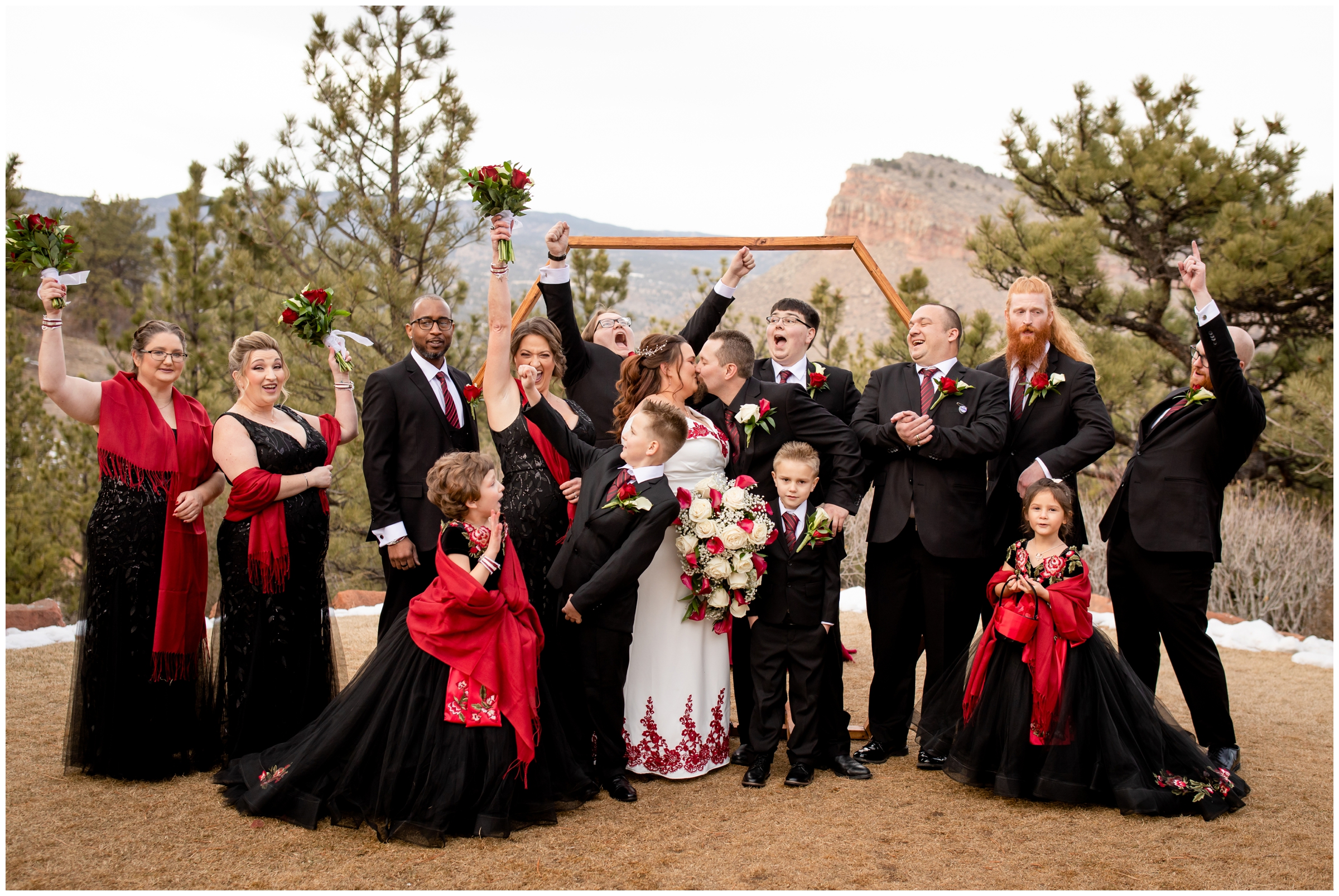 wedding party in red and black cheering for bride and groom at Lionscrest Manor Colorado winter wedding photos 