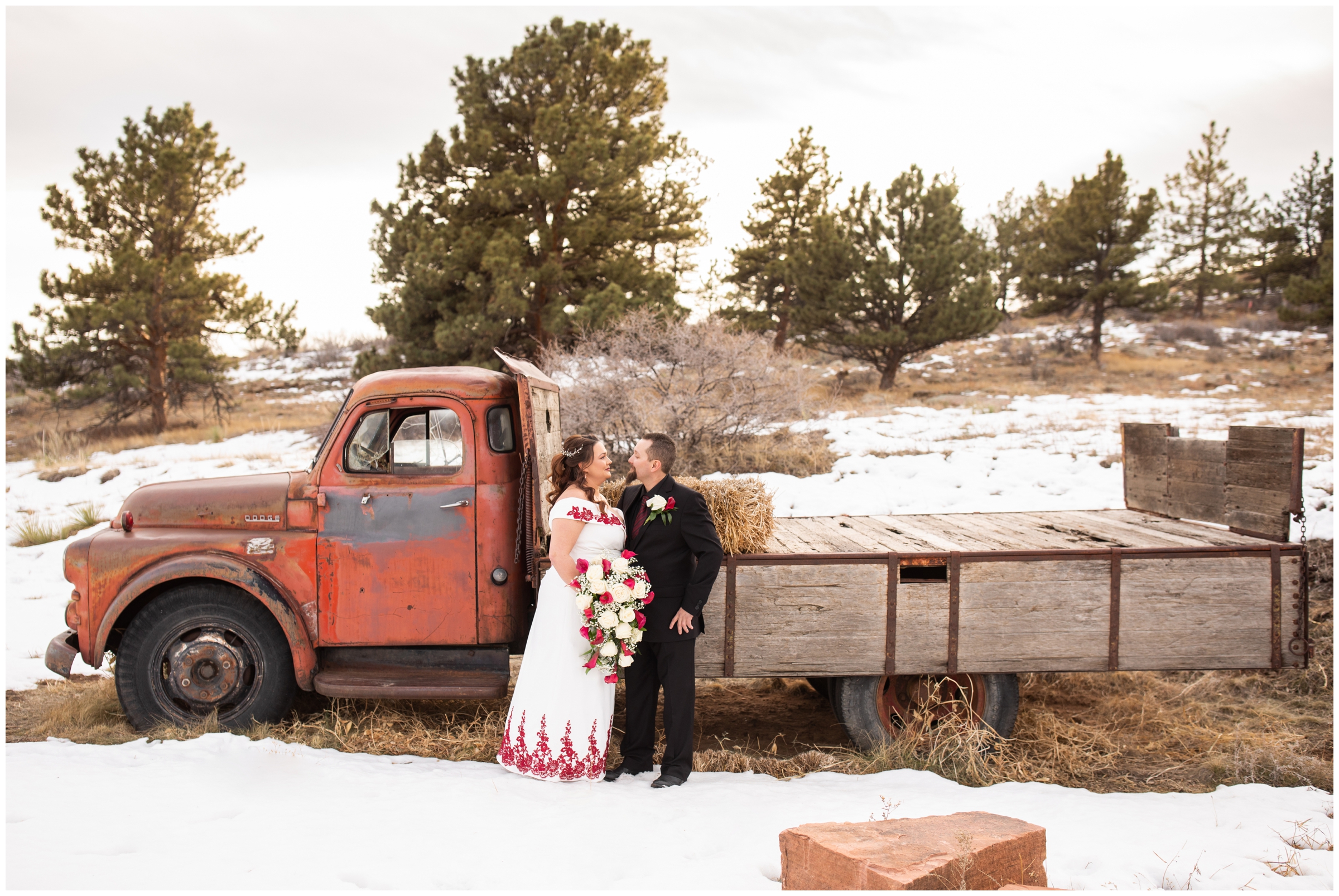 bride and groom posing in front of snowy vintage truck during Lionscrest Manor winter wedding pictures 