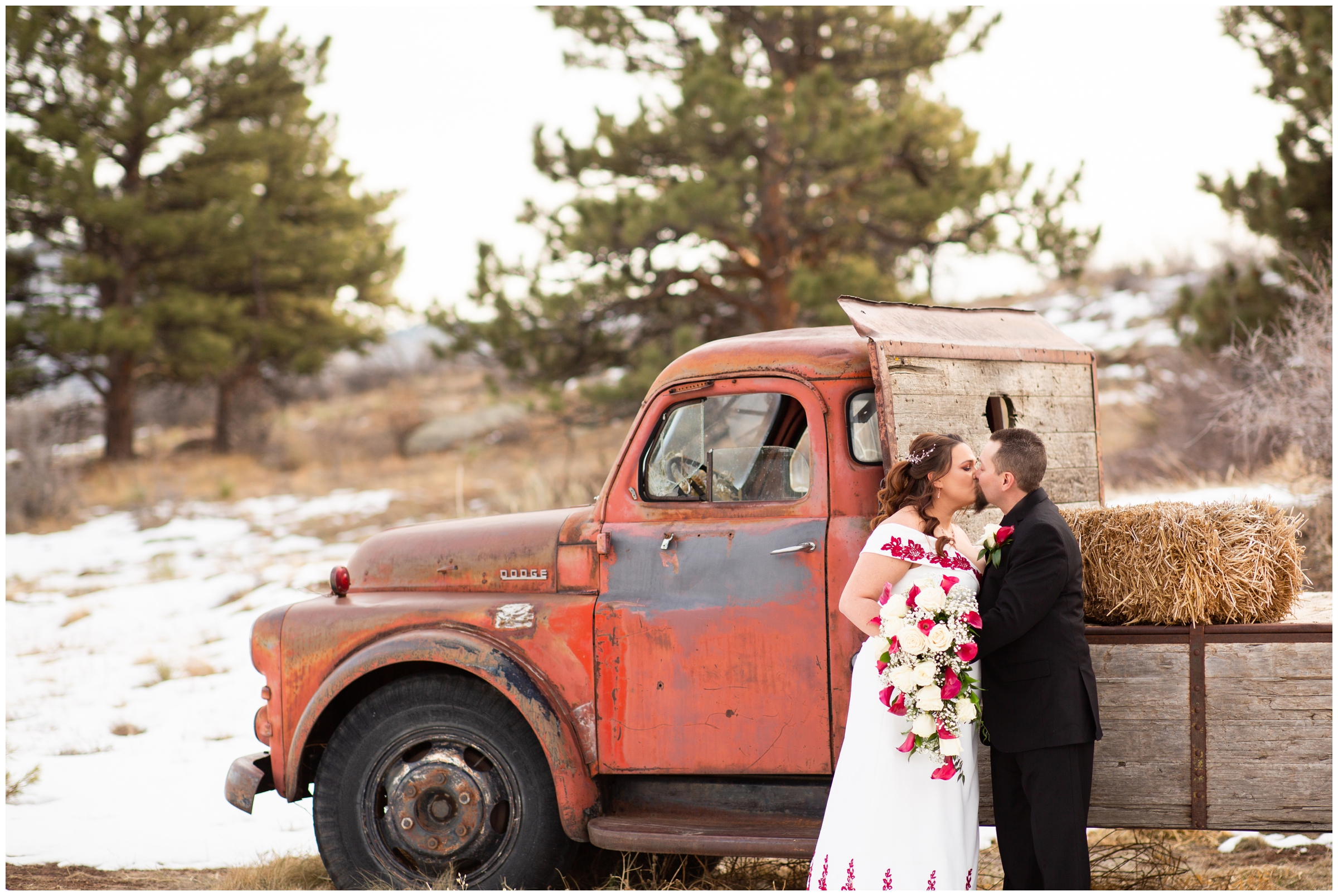 couple kissing in front of rustic vintage truck during snowy winter wedding pictures in Colorado 