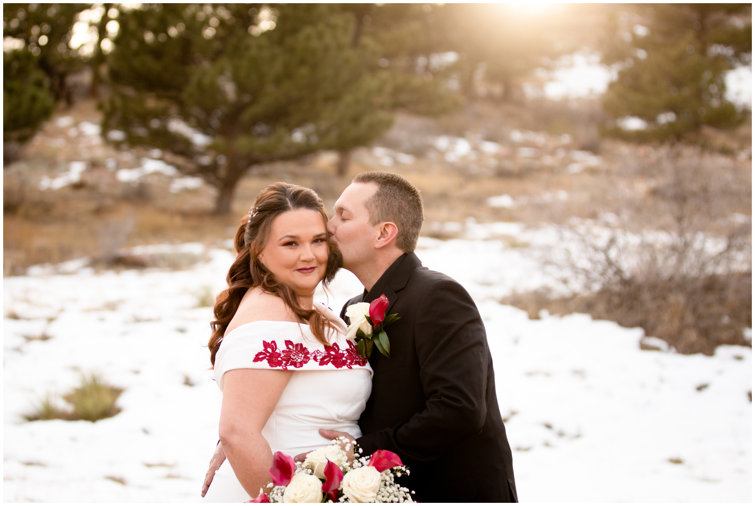 couple kissing surrounded by snow during winter wedding pictures at Lionscrest Manor Colorado 