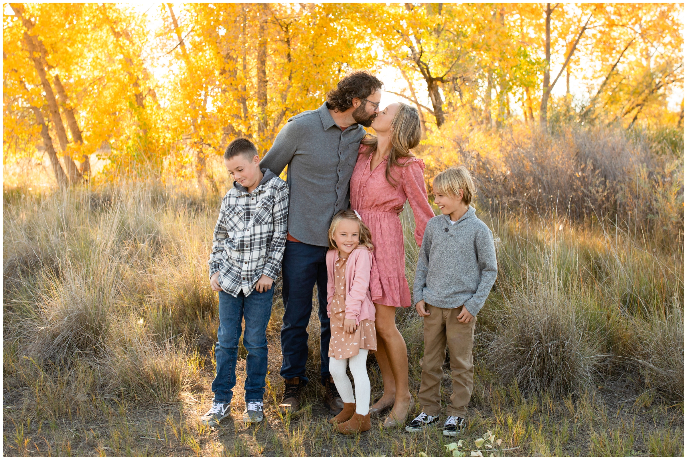 couple kissing and kids looking grossed out during candid family pictures in Longmont