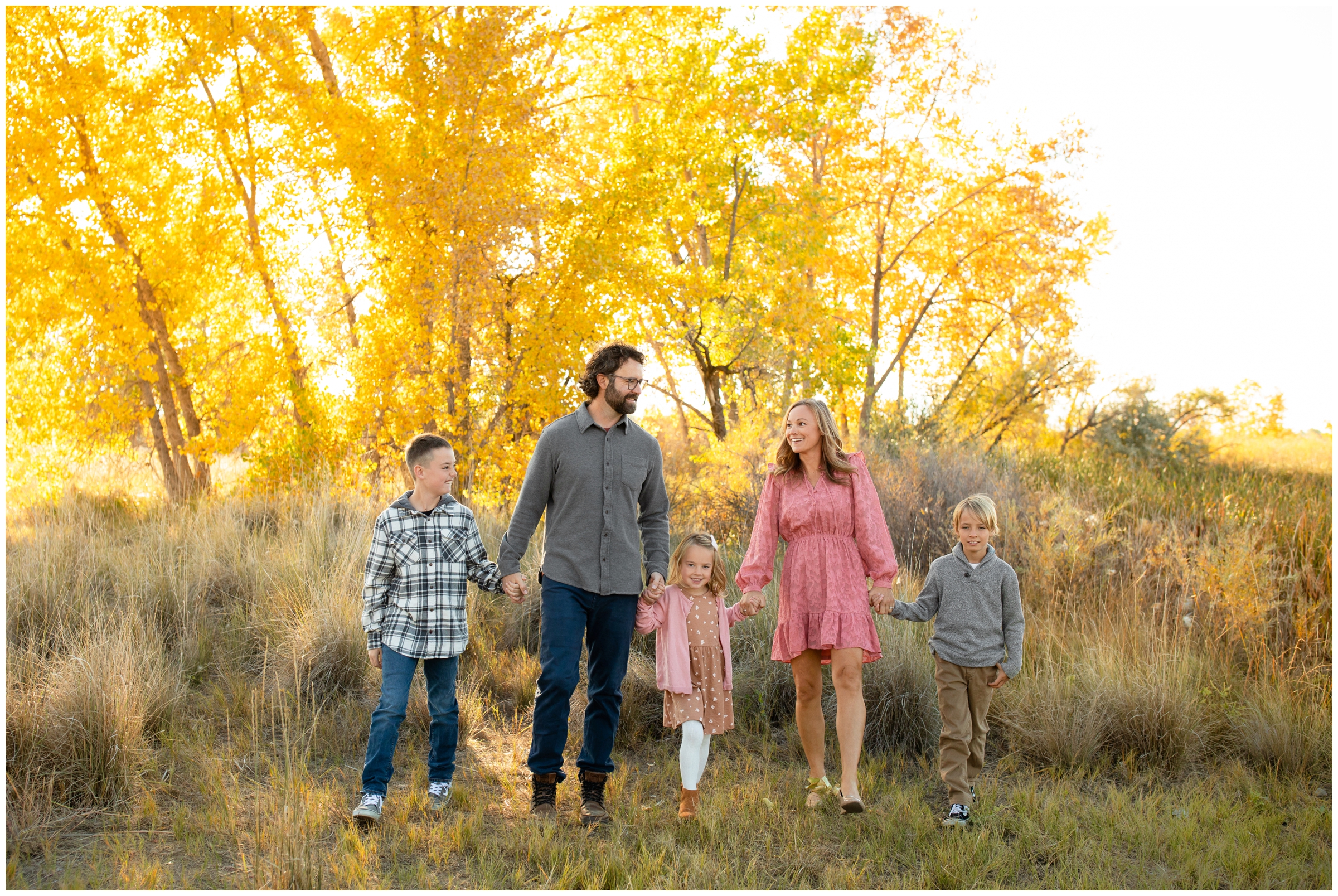 family holding hands and walking during candid family photography session in Colorado