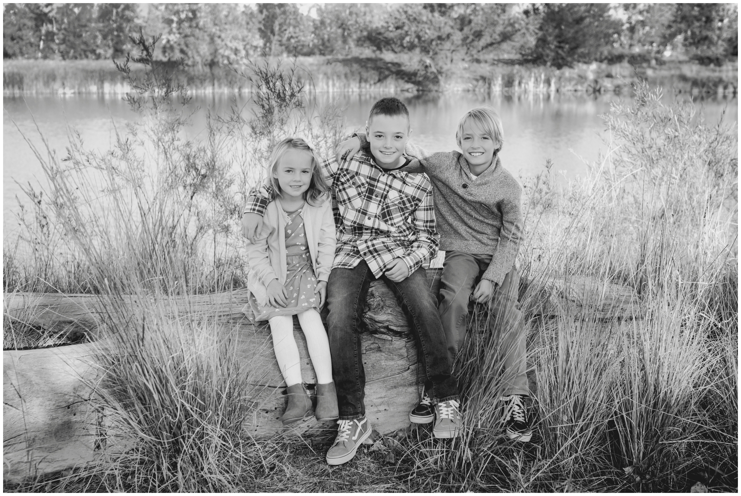 siblings sitting on fallen tree during family pictures in Longmont Colorado 