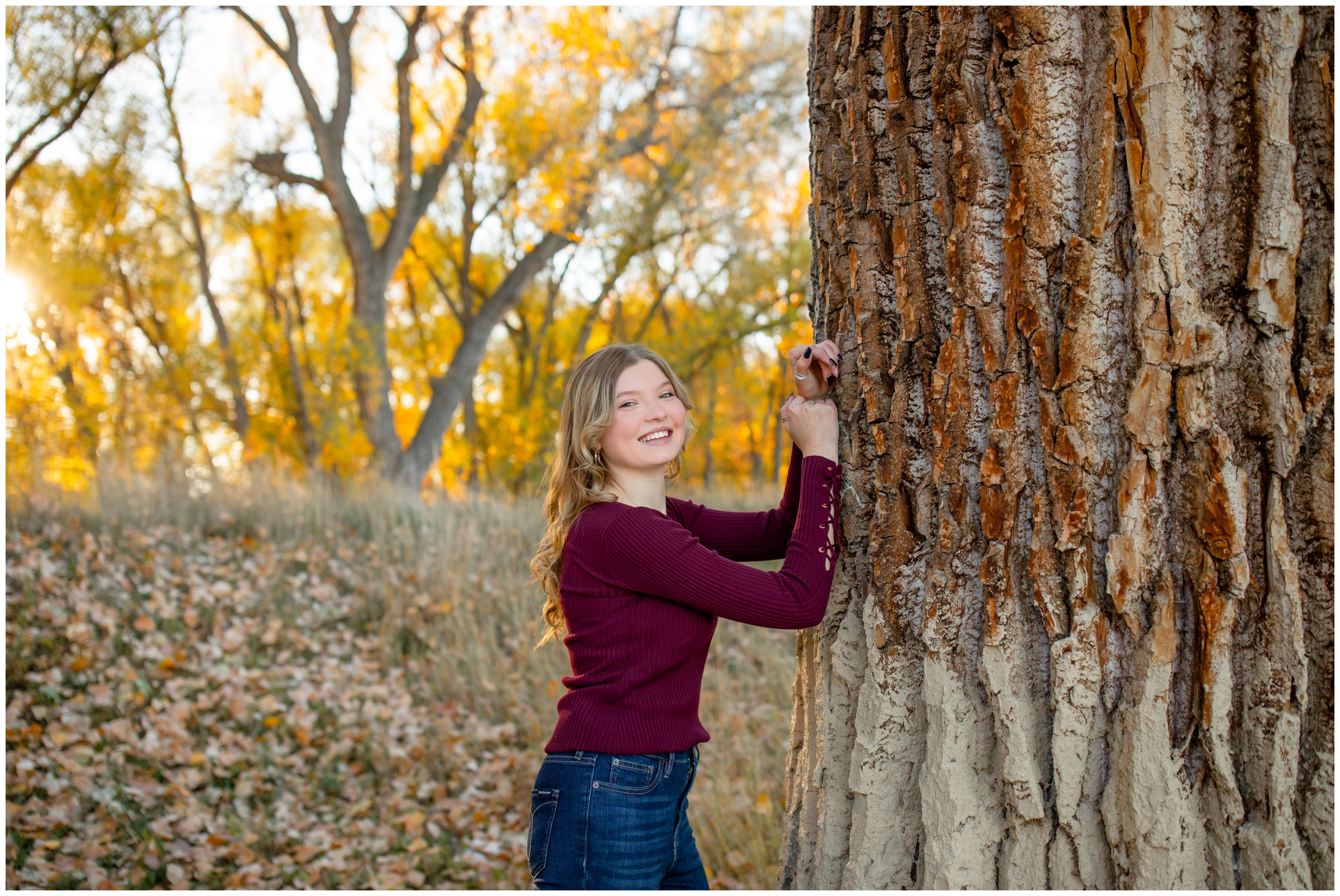 teen leaning against tree during high school graduation portraits at Golden Ponds in Colorado 