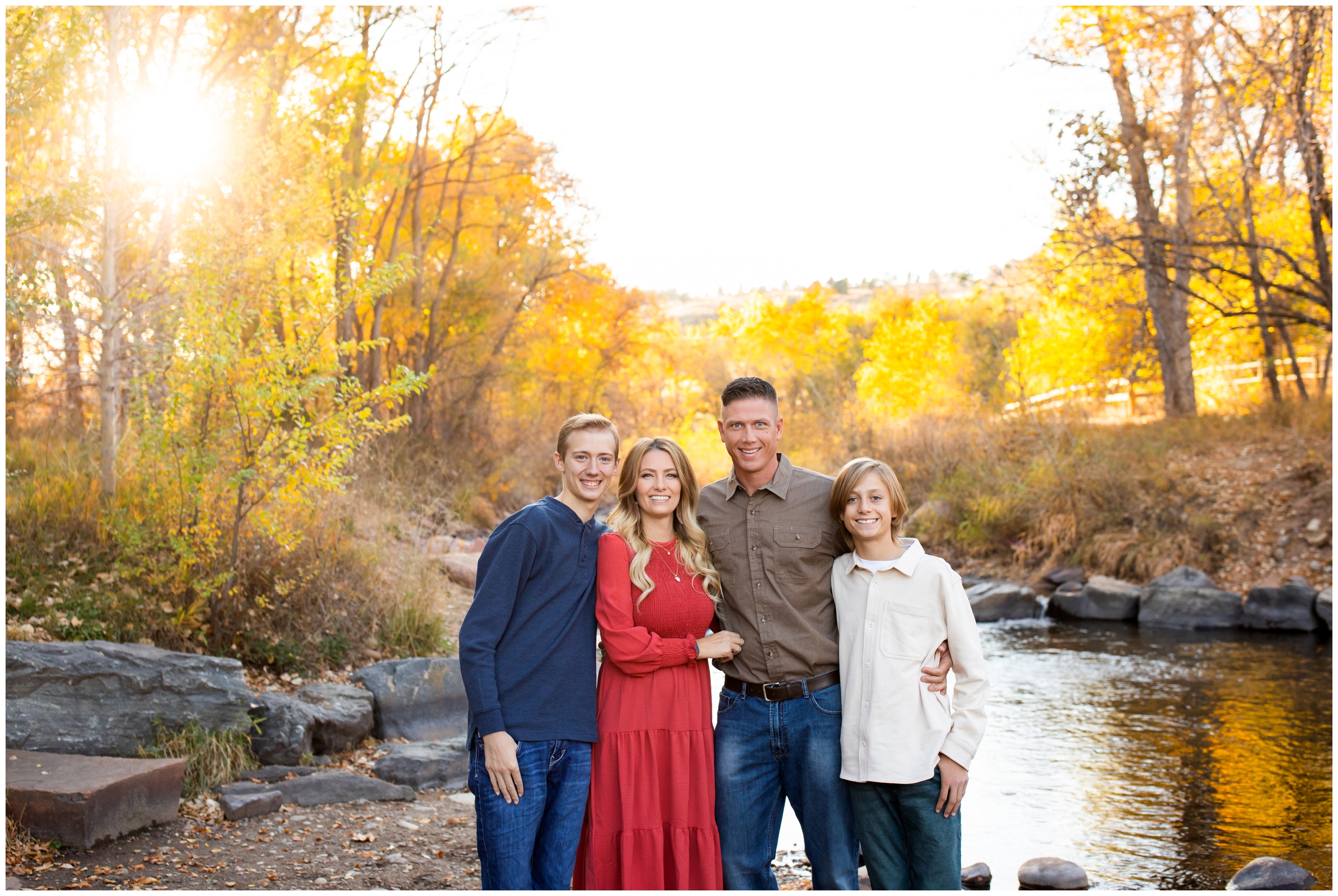 family posing next to a river at Bohn Park in Lyons during fall family pictures 