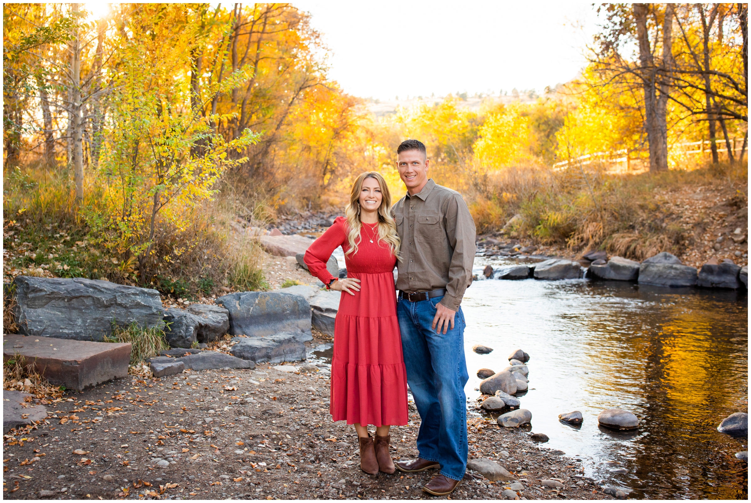 couple posing in front of mountain river during fall engagement portraits in Colorado