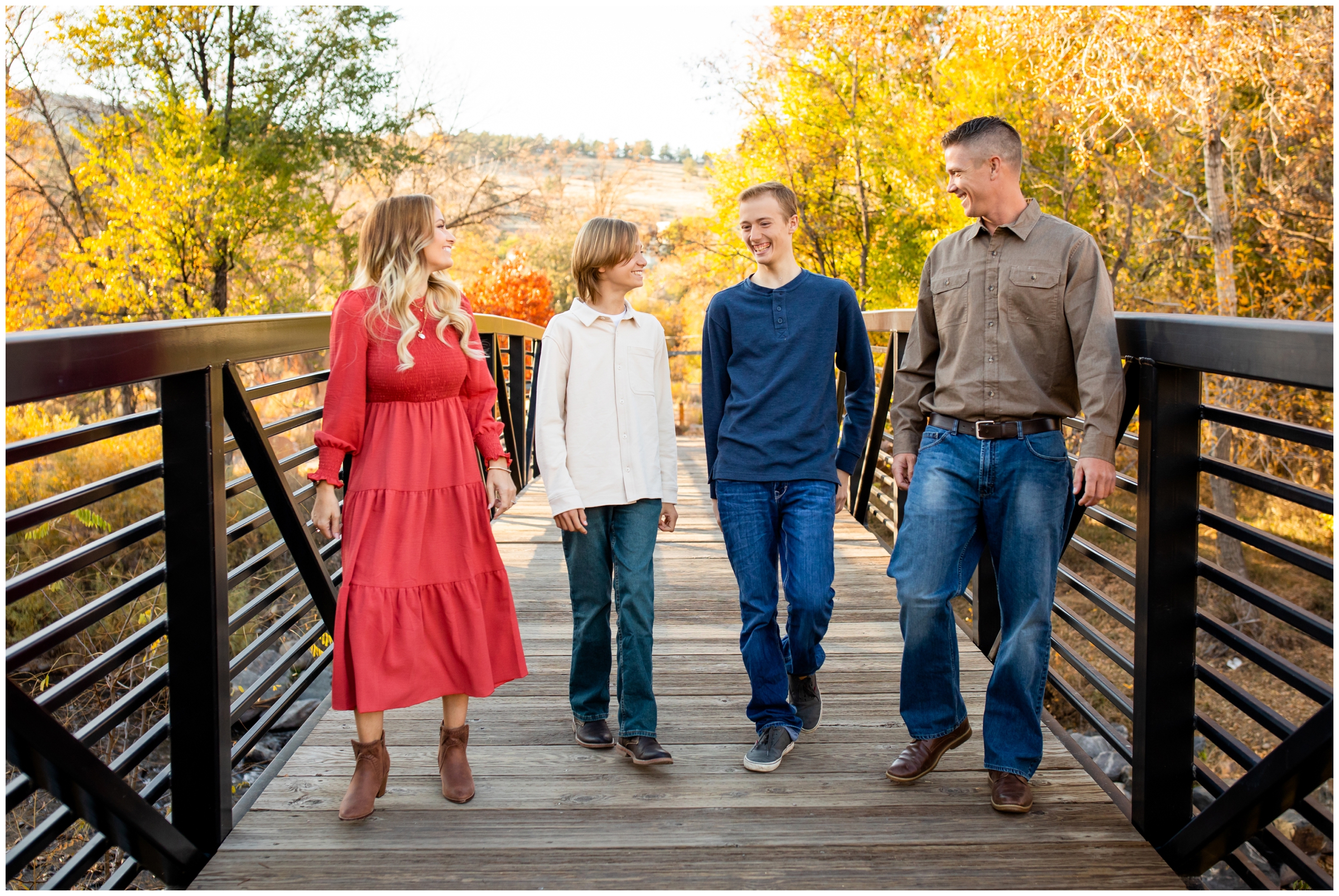 family walking across bridge during candid family photography at Bohn Park in Colorado mountains
