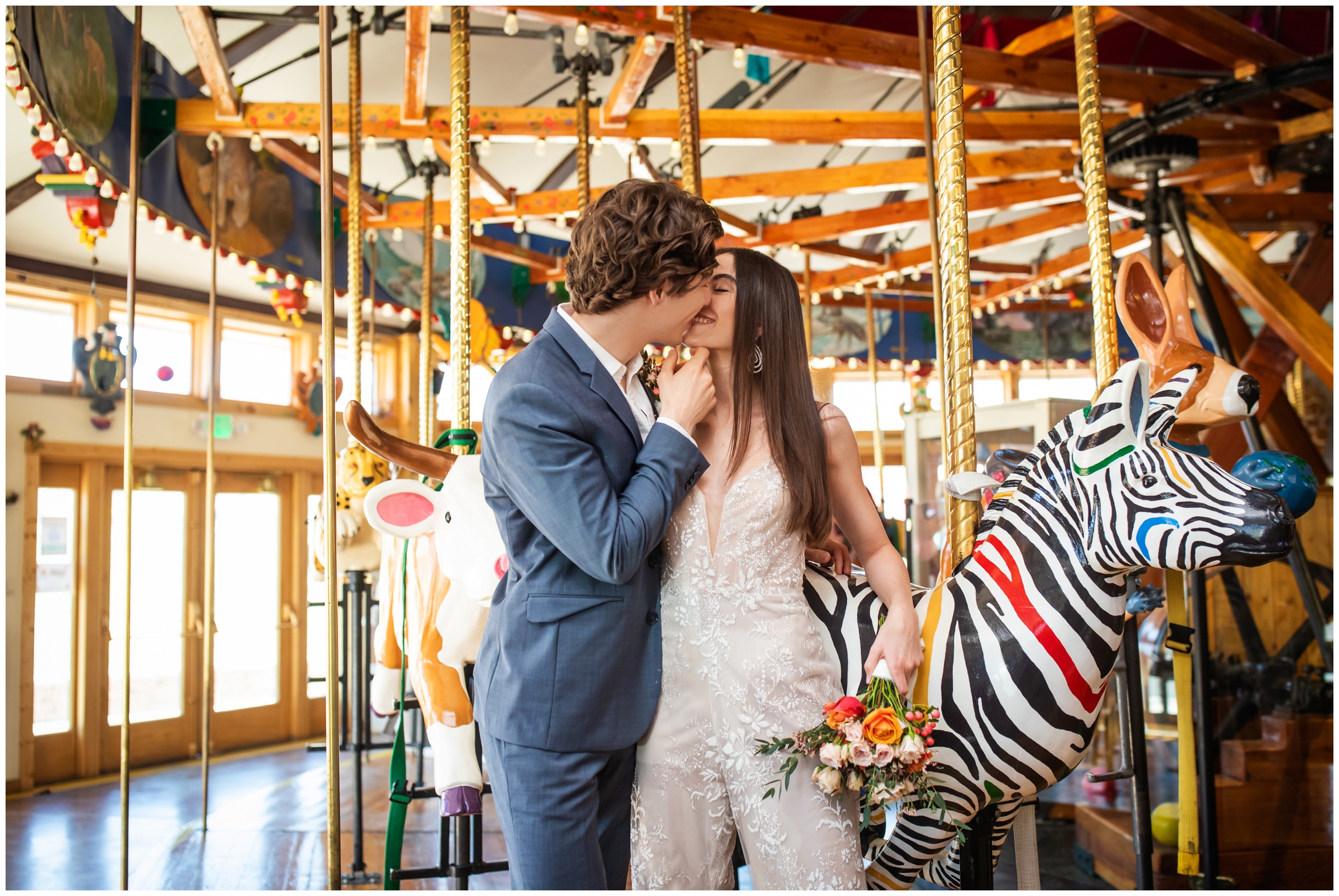 couple kissing on carousel during unique Colorado wedding portraits in Nederland