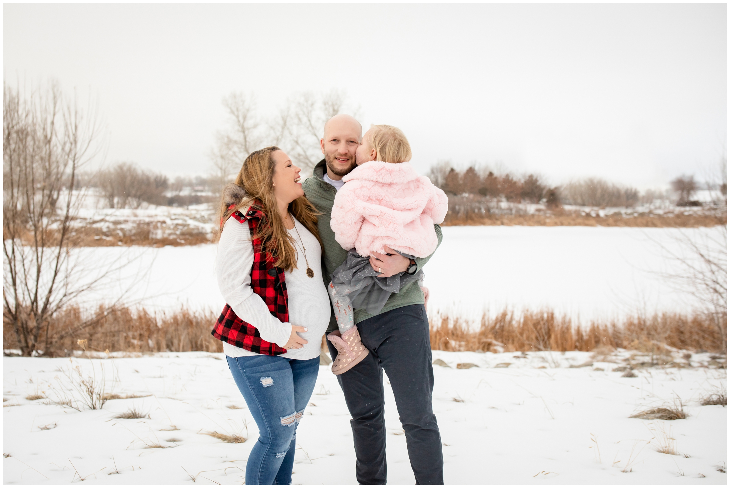 little girl kissing dad's cheek during winter family photos at Sandstone Ranch in Northern Colorado 