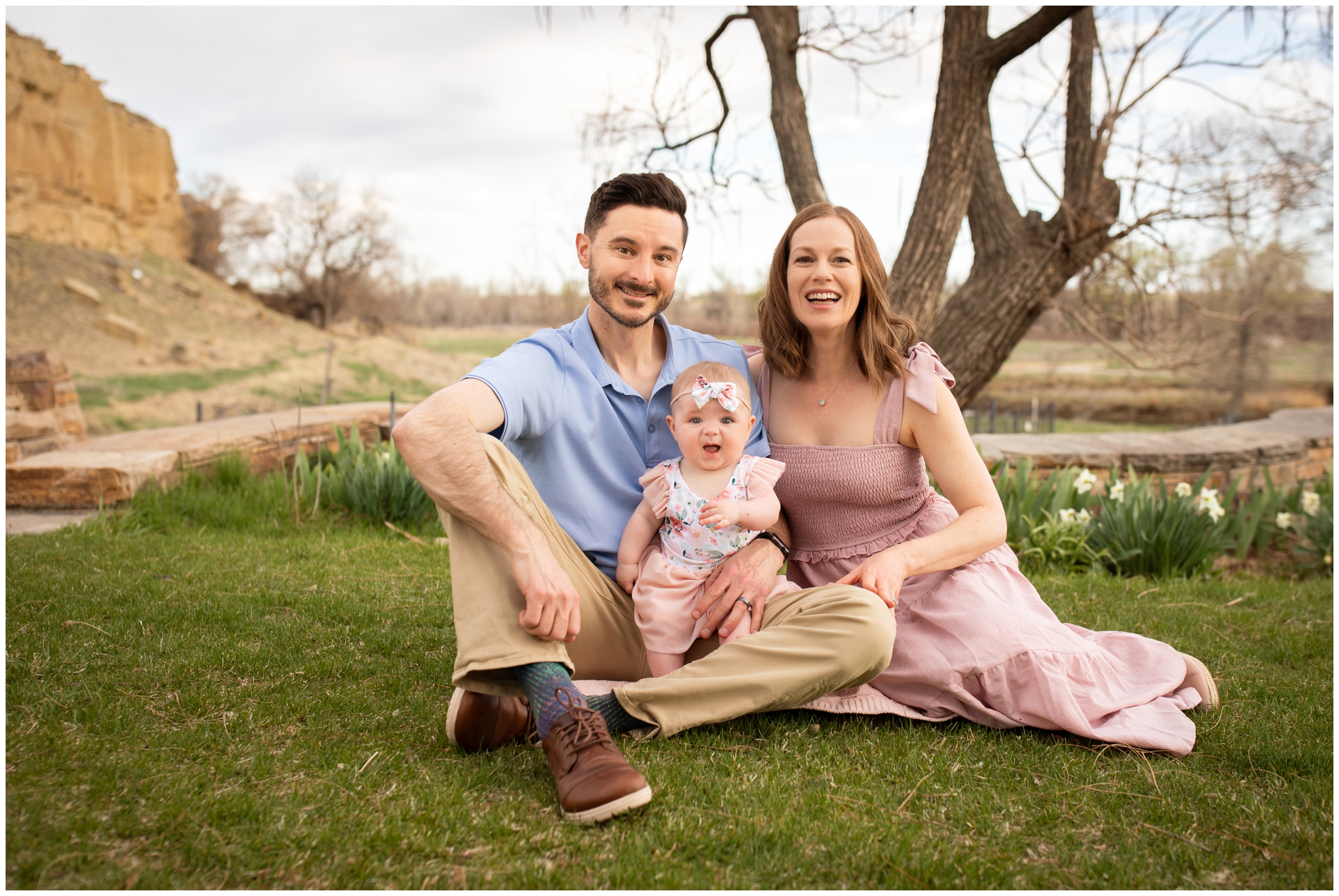 family of three sitting in the grass at Sandstone Ranch during Longmont Colorado family portraits 