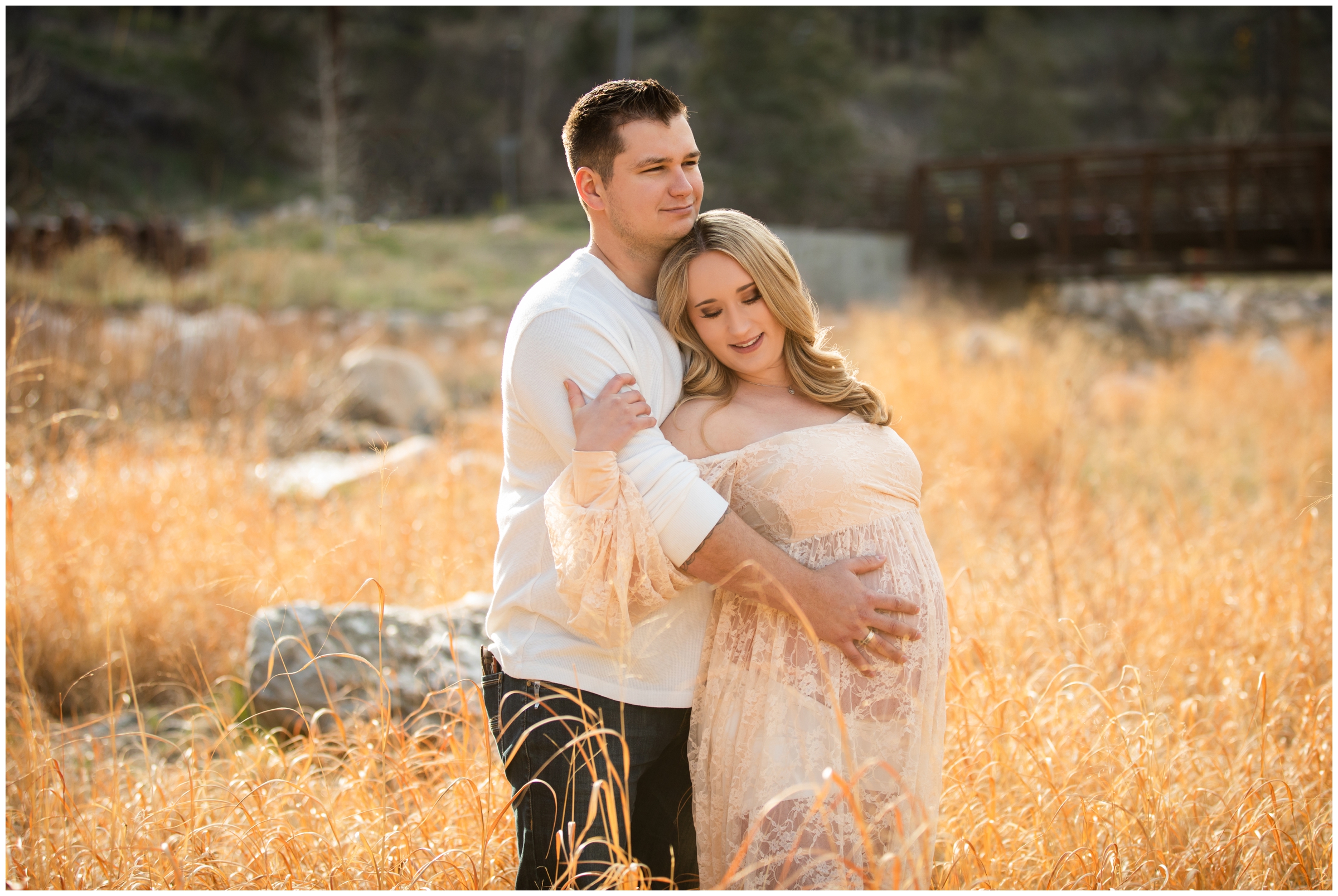 couple posing in golden field during maternity portraits in Loveland Colorado 